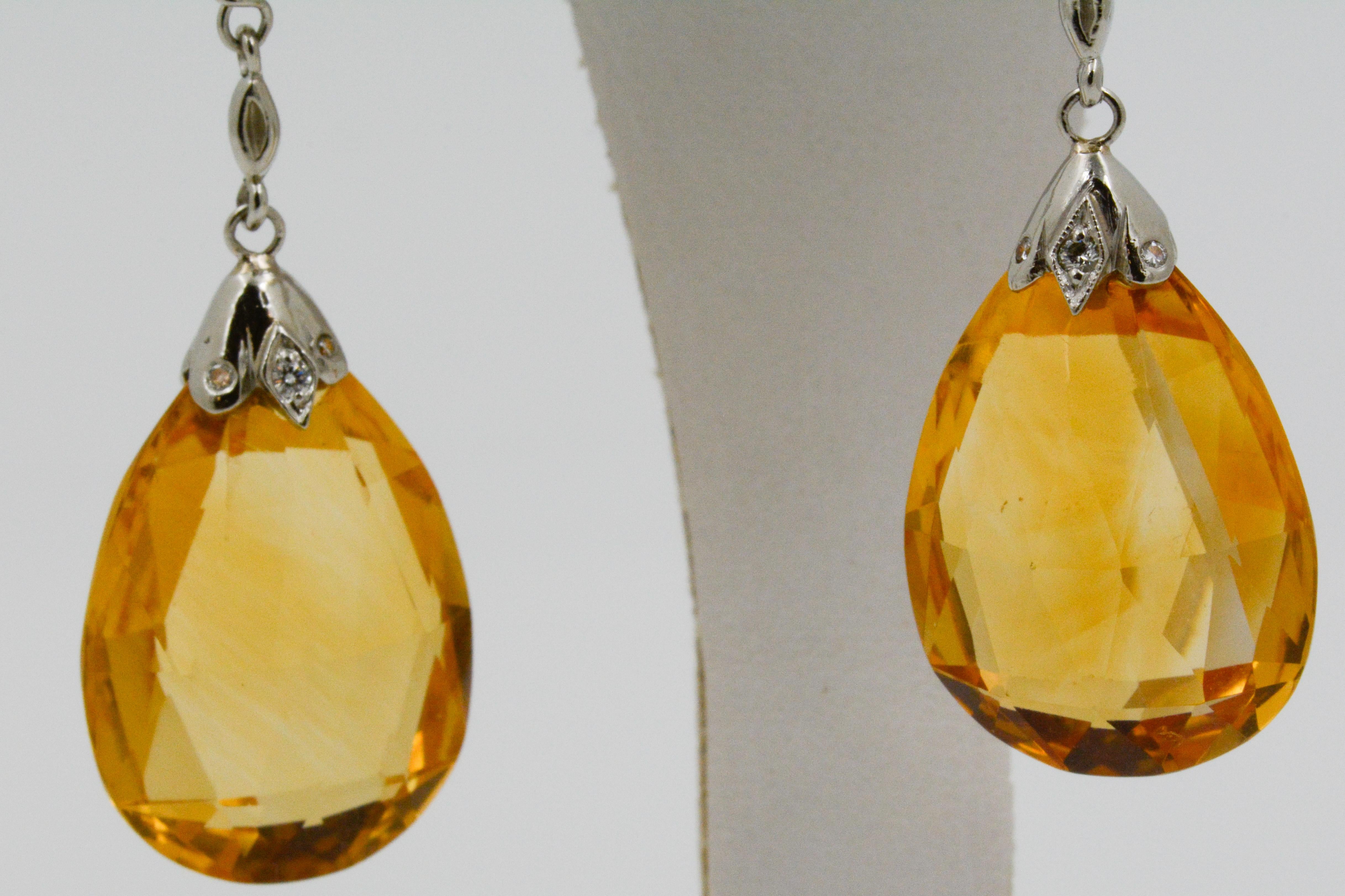 These stunning drop earrings feature two faceted citrines that weigh a total of 50.0 carats. The citrine dangles from platinum that is accented with 16 round diamonds, weighing .16ctw (I-J color and SI clarity), four beaded diamonds weighing,