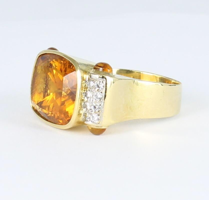 A bright and sunny oval citrine blazes from the center of this handsome 18 karat yellow gold ring.  The citrine sits east-west in the substantial mounting, and there is a rectangle of pave-set diamonds on either side of the center stone.  This