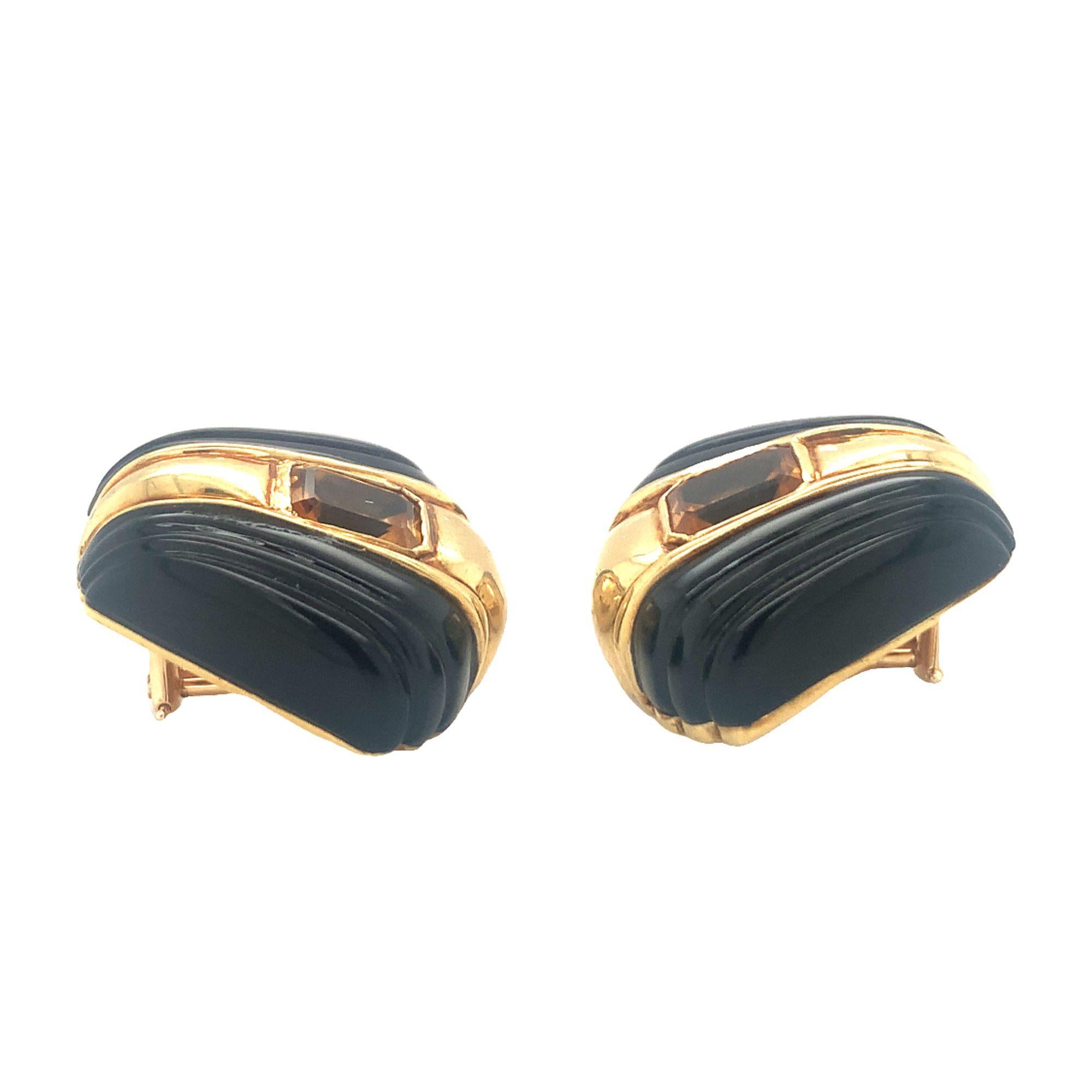 One pair of citrine and black onyx 18K yellow gold earclips featuring fluted black onyx portions and two bezel set, emerald-cut citrines totaling 4 ct. Circa 1970s.

Contrasting, fluted, dashing.

Additional information:
Metal: 18K yellow