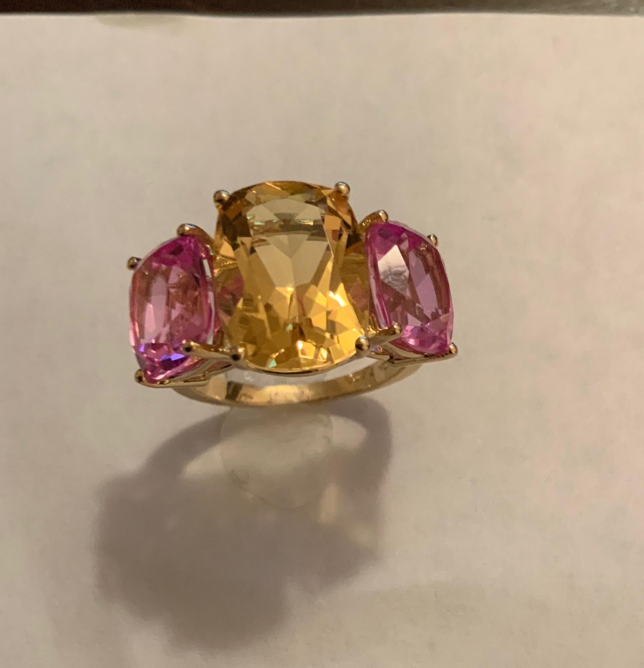 18kt Yellow Gold Three Stone faceted Cushion Cut Ring with center Citrine and Pink Topaz finished with a tapered split shank.

This elegant cocktail ring measures 1 1/4