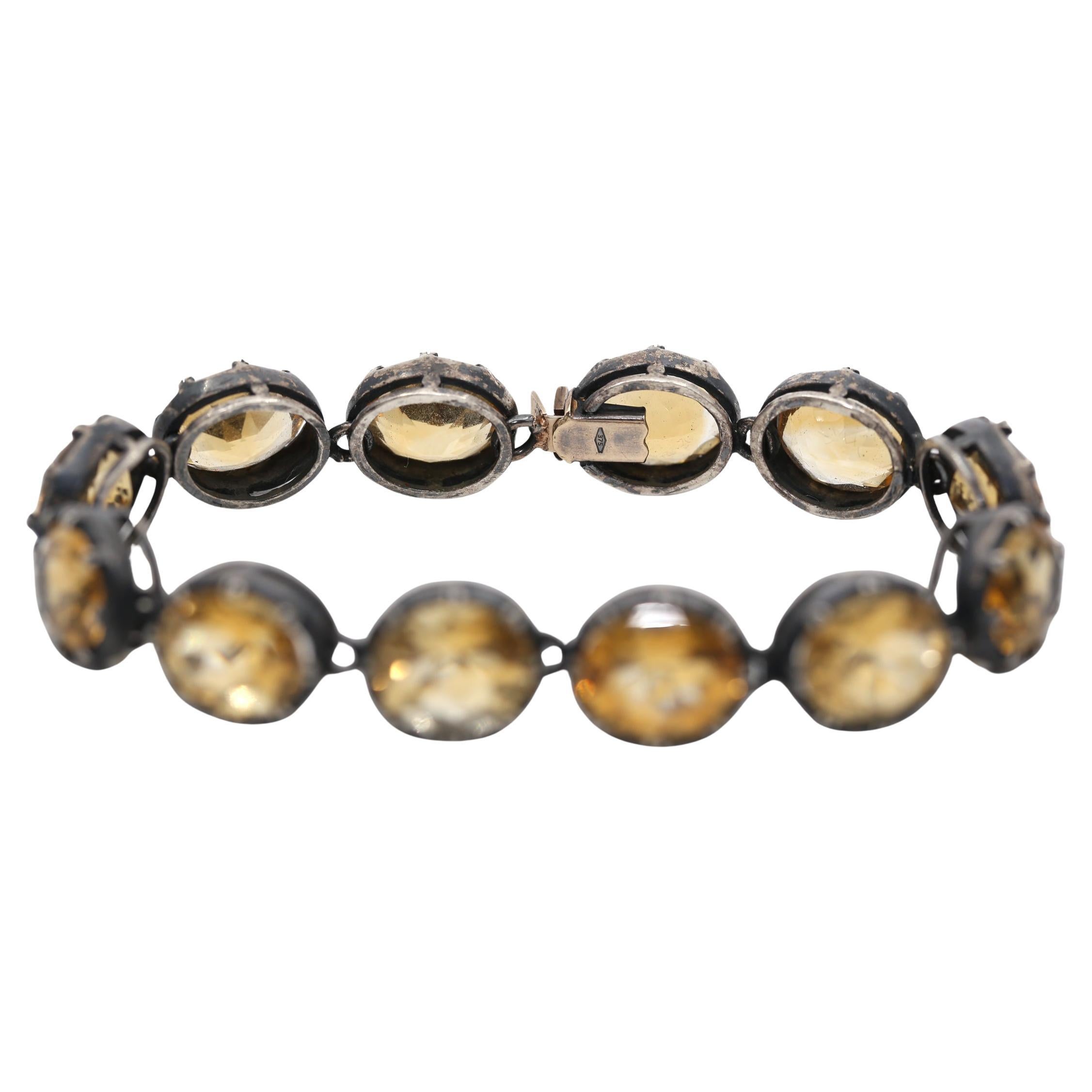 Ein Citrin-Armband aus 9 Karat  Gelbgold und Silber, besetzt mit einer Reihe oval geschliffener Citrine in gequetschten Fassungen, gestempelt 375. Entstanden zu Beginn des 20. Jahrhunderts.

Ein echter zukünftiger Klassiker, dessen Wert im Laufe der