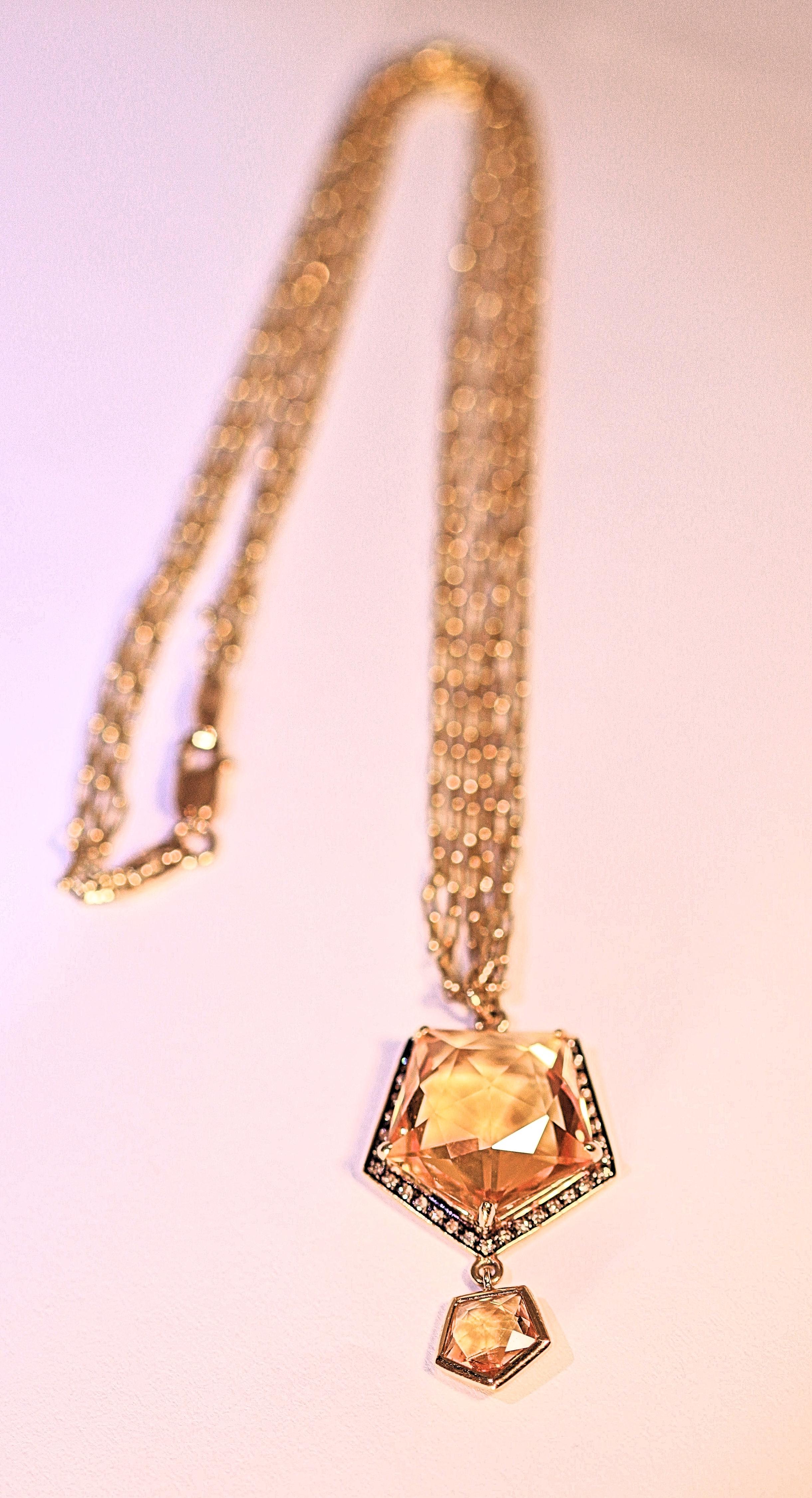 A delightful 18 karat yellow gold pendant with one large citrine and one small citrine.  The large citrine is surrounded by small brown diamonds with .21 carat total weight.  The dangling citrines measure  1 1/2 inches long.  The chain is a triple