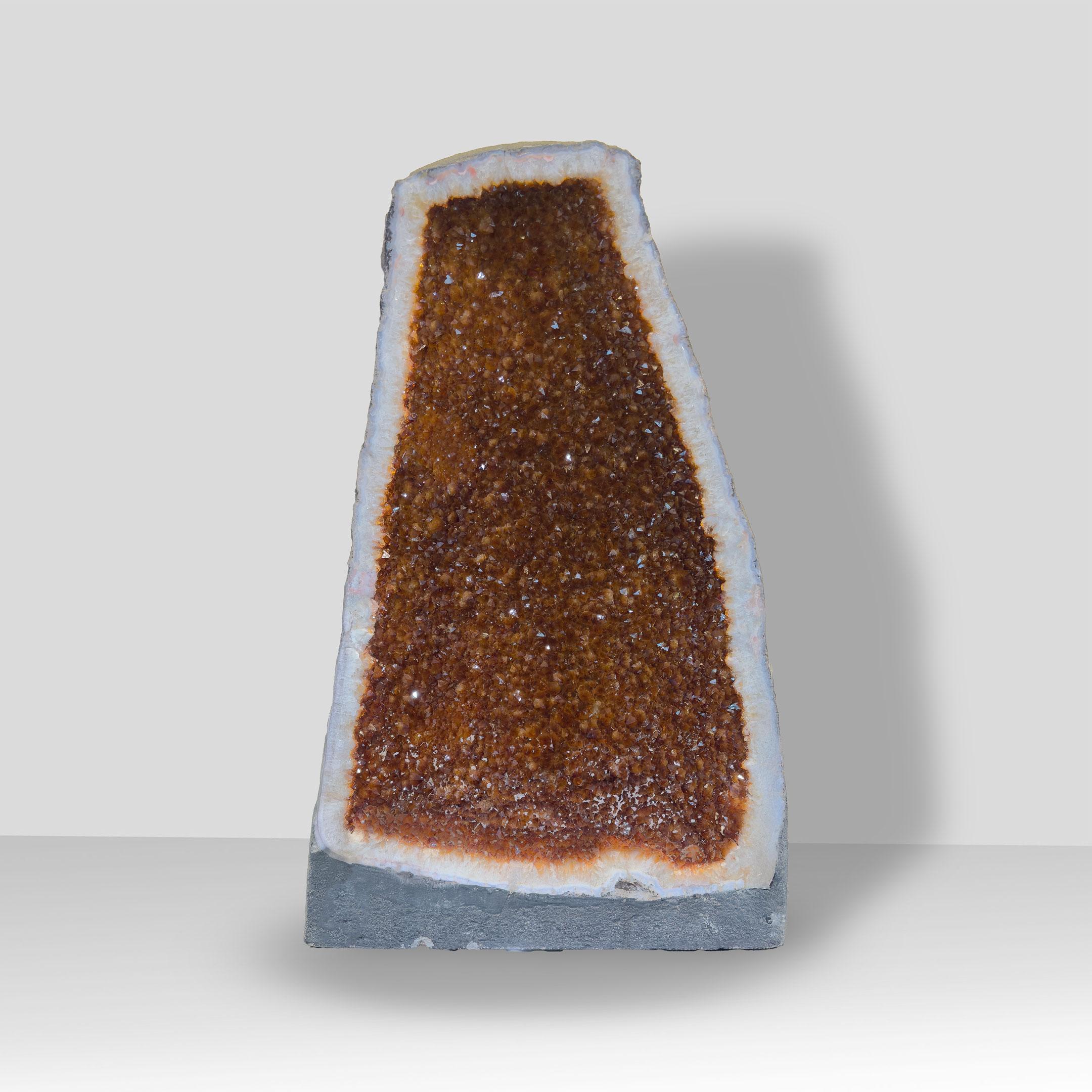 This striking Citrine Cathedral from Brazil rises 26 inches tall and reveals a fully crystallized interior glowing with warm golden to amber hues. The elongated triangular formation creates a naturally architectural silhouette, while the densely