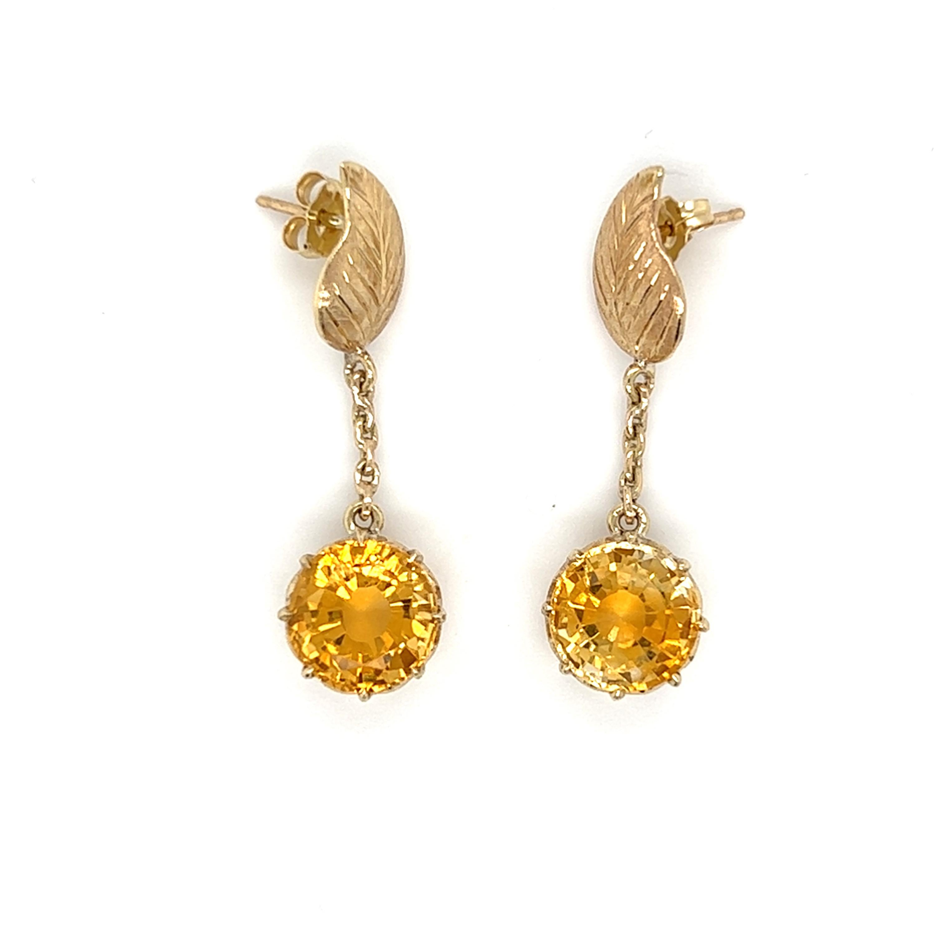 One pair of 14 karat yellow gold earrings featuring two (2) 9.3mm round faceted citrines that weigh approximately 4.0 carats total weight set in a crown style 8-prong baskets dangling from a 14 karat yellow gold diamond cut finish leaf post.  The