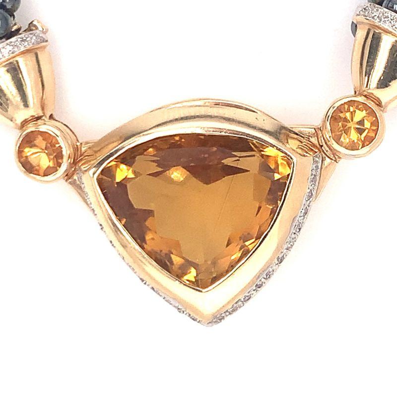 One citrine, diamond and hematite bead and 14K yellow gold necklace featuring 5 strands of hematite beads centering one triangular mixed cut citrine weighing 30 ct. flanked by two round brilliant citrines weighing a total of 1.25 ct. Accented by 42