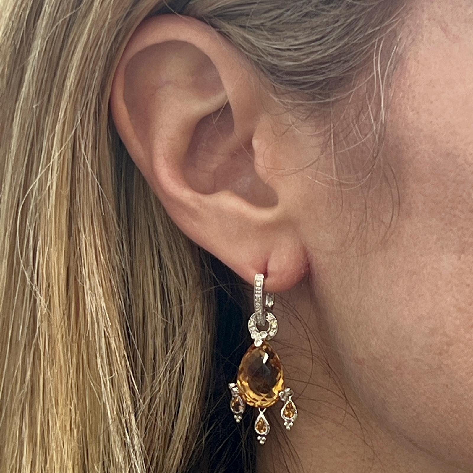 Beautiful citrine and diamond dangle earrings crafted in 14 karat white gold. The earrings feature briolette faceted citrine gemstones and 38 round brilliant cut diamonds weighing approximately .20 CTW. The earrings measures 1.50 x .50 inches, and