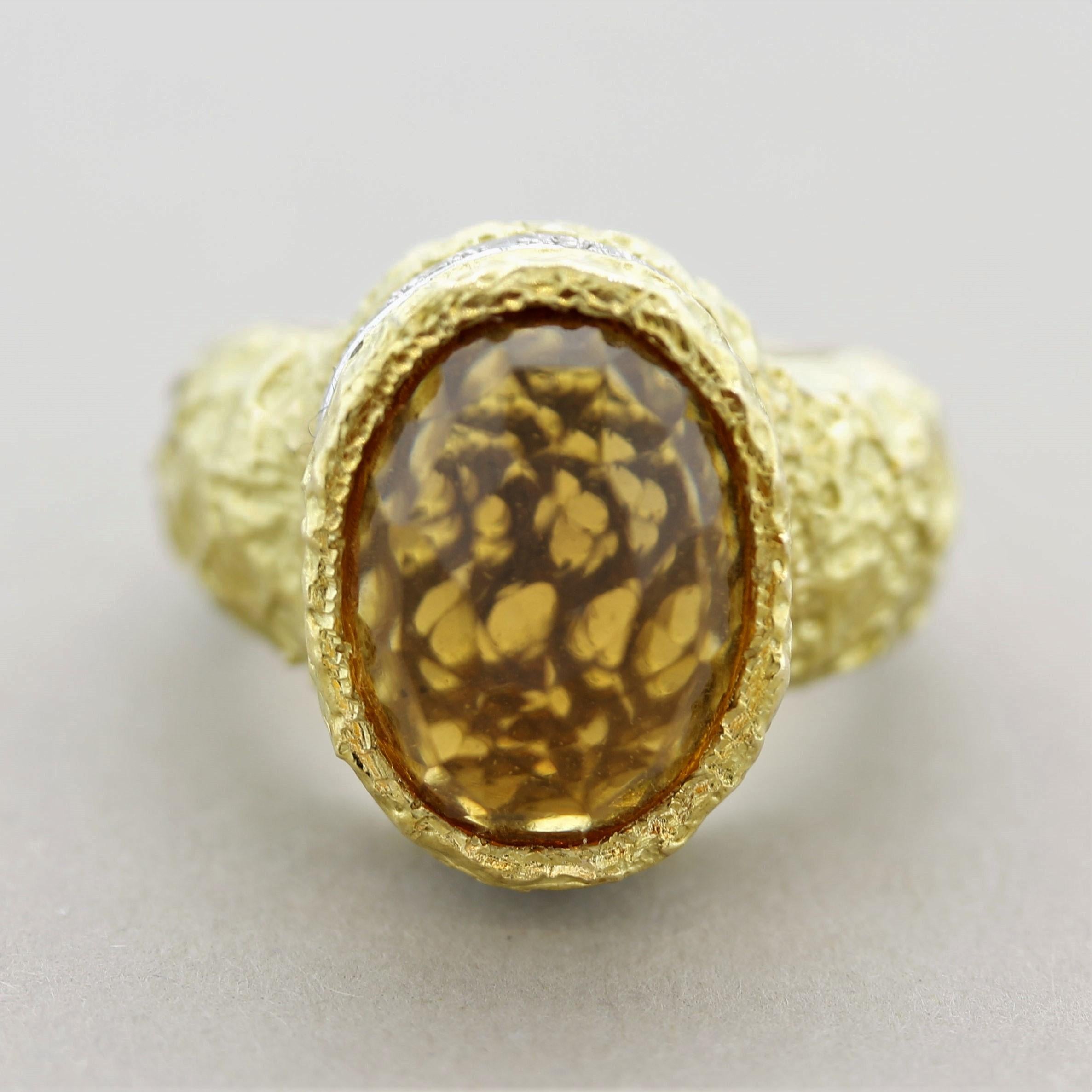 A large citrine weighing 11 carats! It is dome-shaped and has a unique rose-cut with a vivid yellowish-orange color. Accenting the ring are 0.45 carats of round brilliant-cut diamonds set below the citrine in white gold. Hand-fabricated in 18k gold
