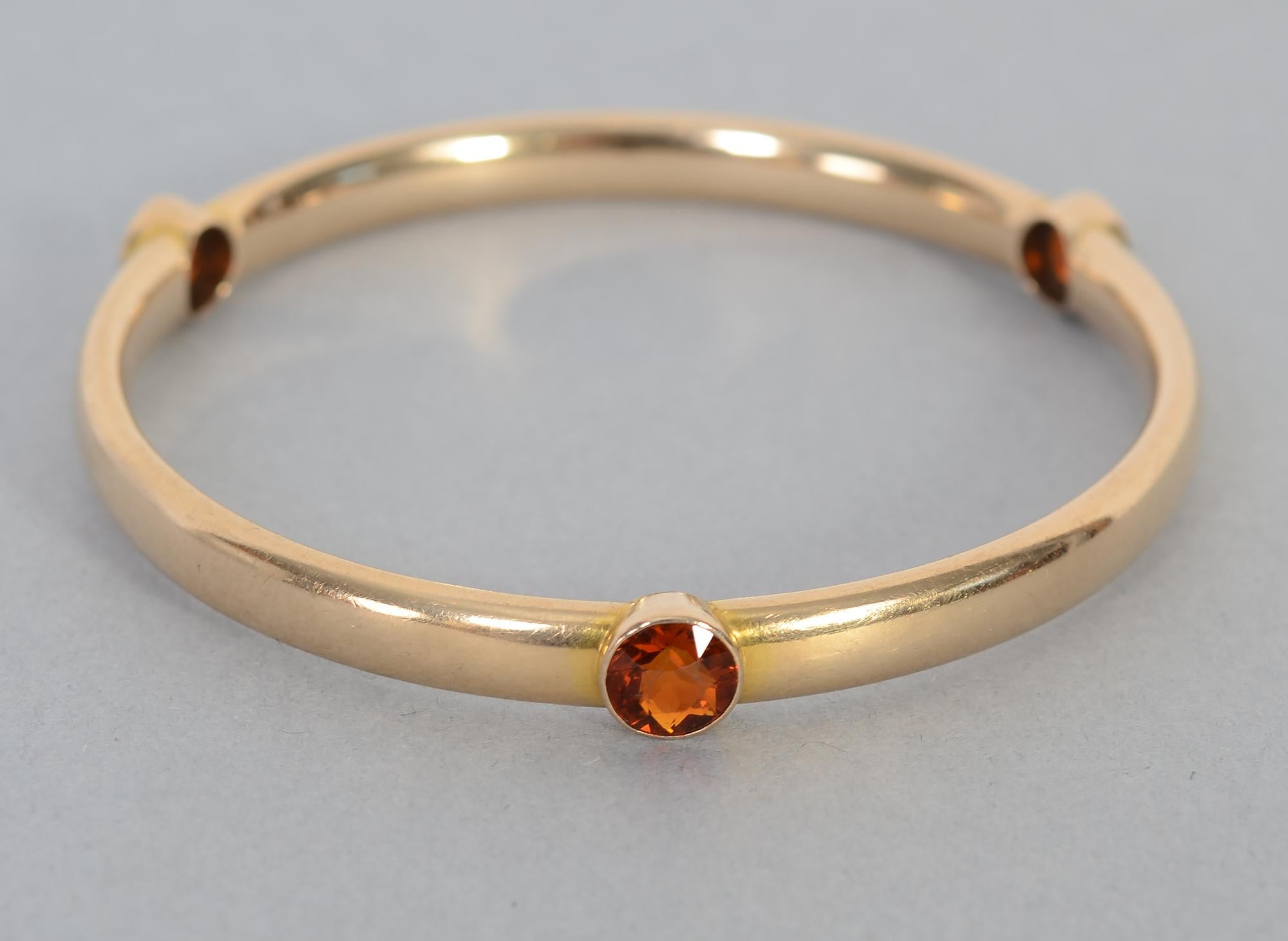 What makes this classic 14 karat gold bangle bracelet unusual are the three faceted citrine stones spaced throughout it.
Each stone is 1/4