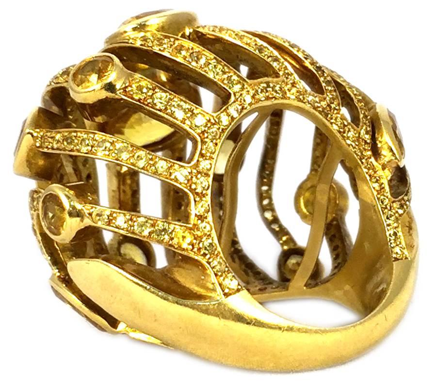 A chunky dome shaped cocktail ring, with undulated interspaced undulated elements, accented small and larger citrines, mounted on 18kt yellow gold. Circa 1970.