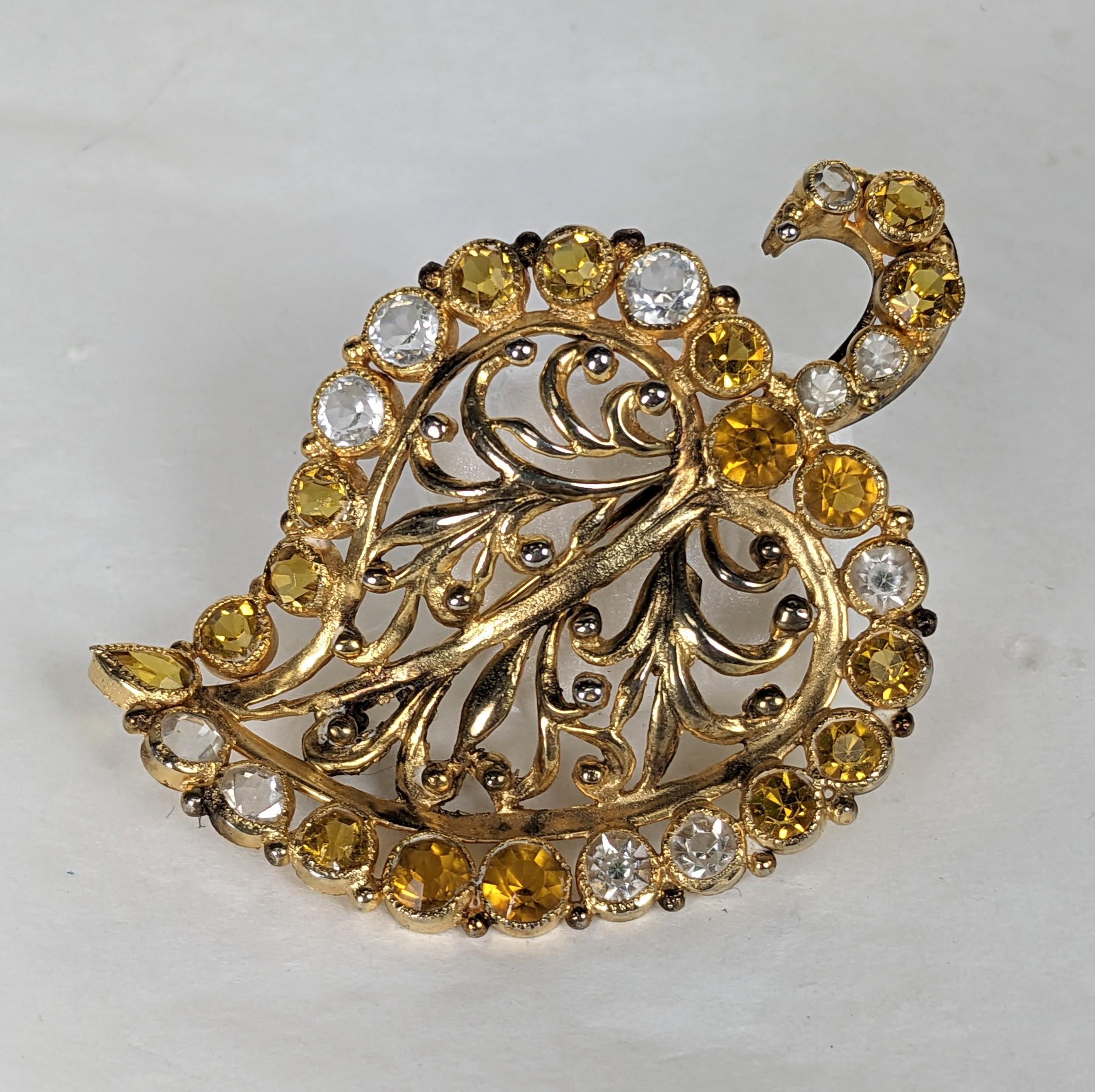 Elegant Hobe leaf brooch of gilt plate bronze and brass metal with collet set vari shaped faceted crystals in clear and citrine tones. The leaf's center made of delicate pierced work of gilt foliate motifs. Excellent Condition, Signed Hobe. Length 2