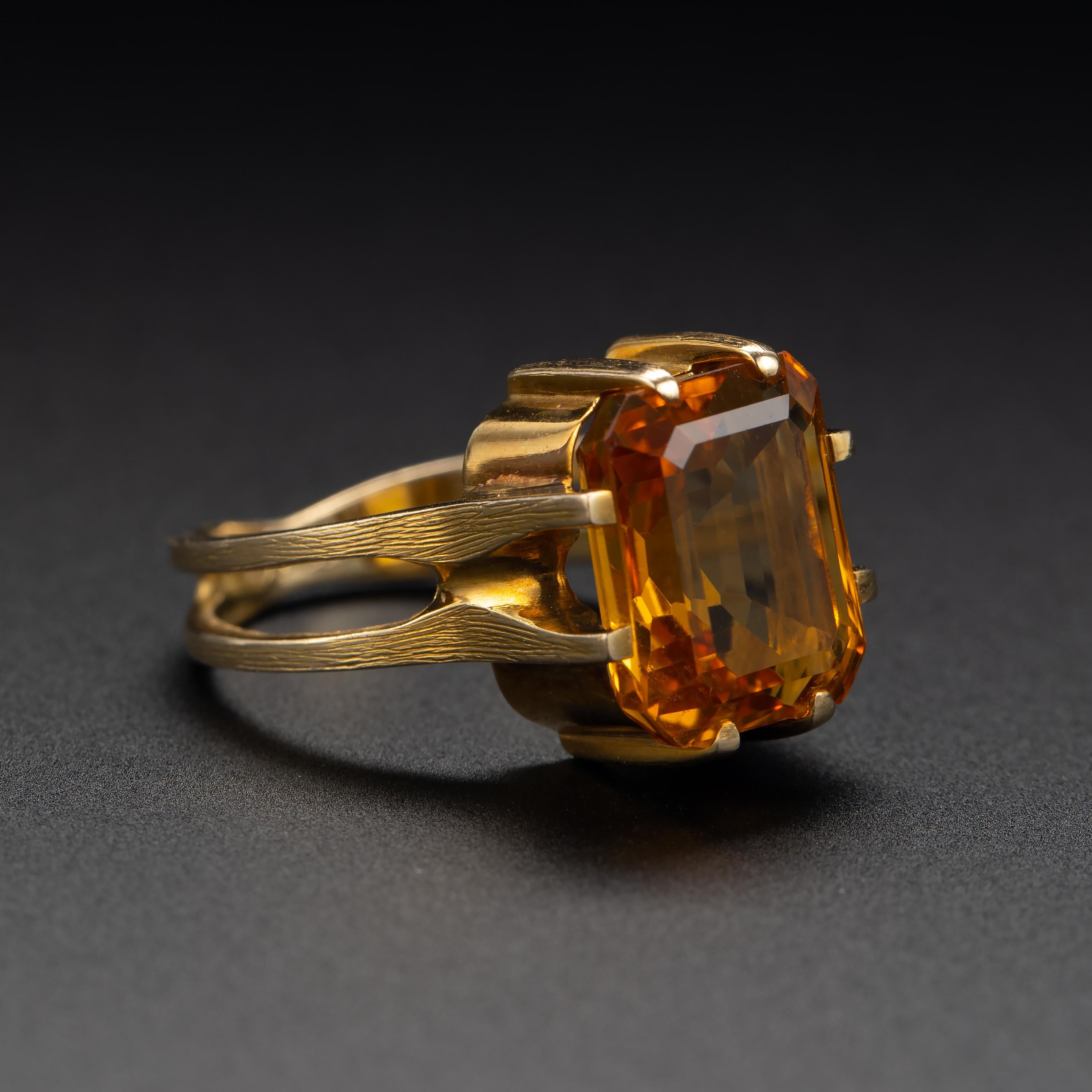 A rich, vividly-saturated natural citrine measuring approximately 12.27mm x 9.95 and weighing approximately 5 ¼ carats is the focal point of this truly unique, architectural ring from the Midcentury. While there is no maker's mark, the ring is