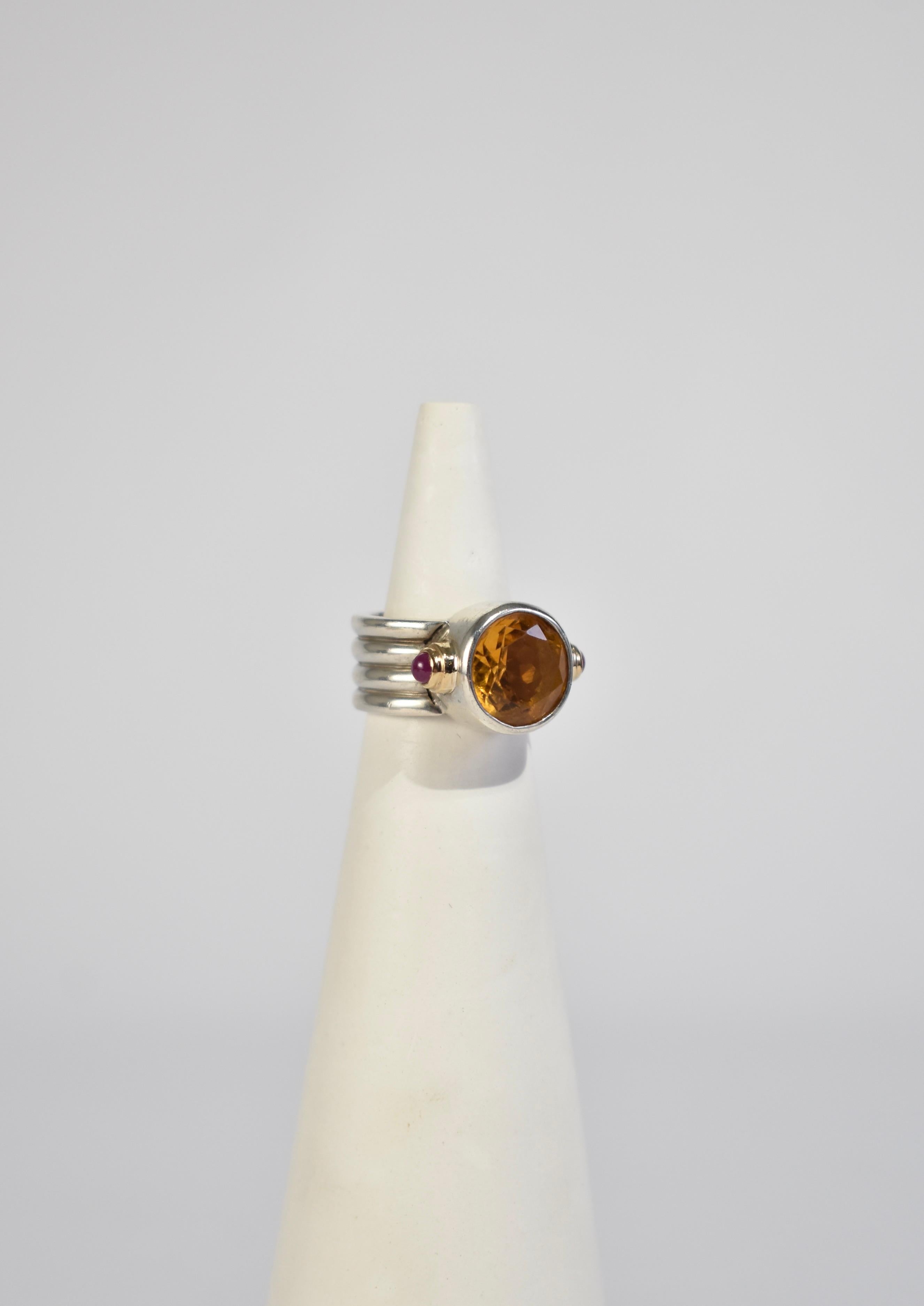 Beautiful vintage sterling ribbed ring with a faceted citrine stone, petite rubies, and gold detail. Stamped sterling.

Material: Sterling silver, 14k gold, citrine, ruby.