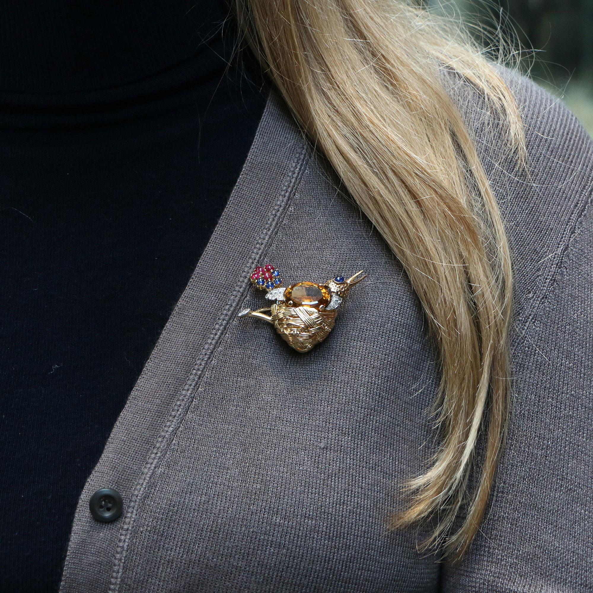 A beautifully unique French nesting bird brooch set in 18k yellow gold. 

The brooch is predominantly set with a 13.00 carat (estimated) oval shaped orange-brown citrine which forms the main body of the nesting bird. The birds head has been designed