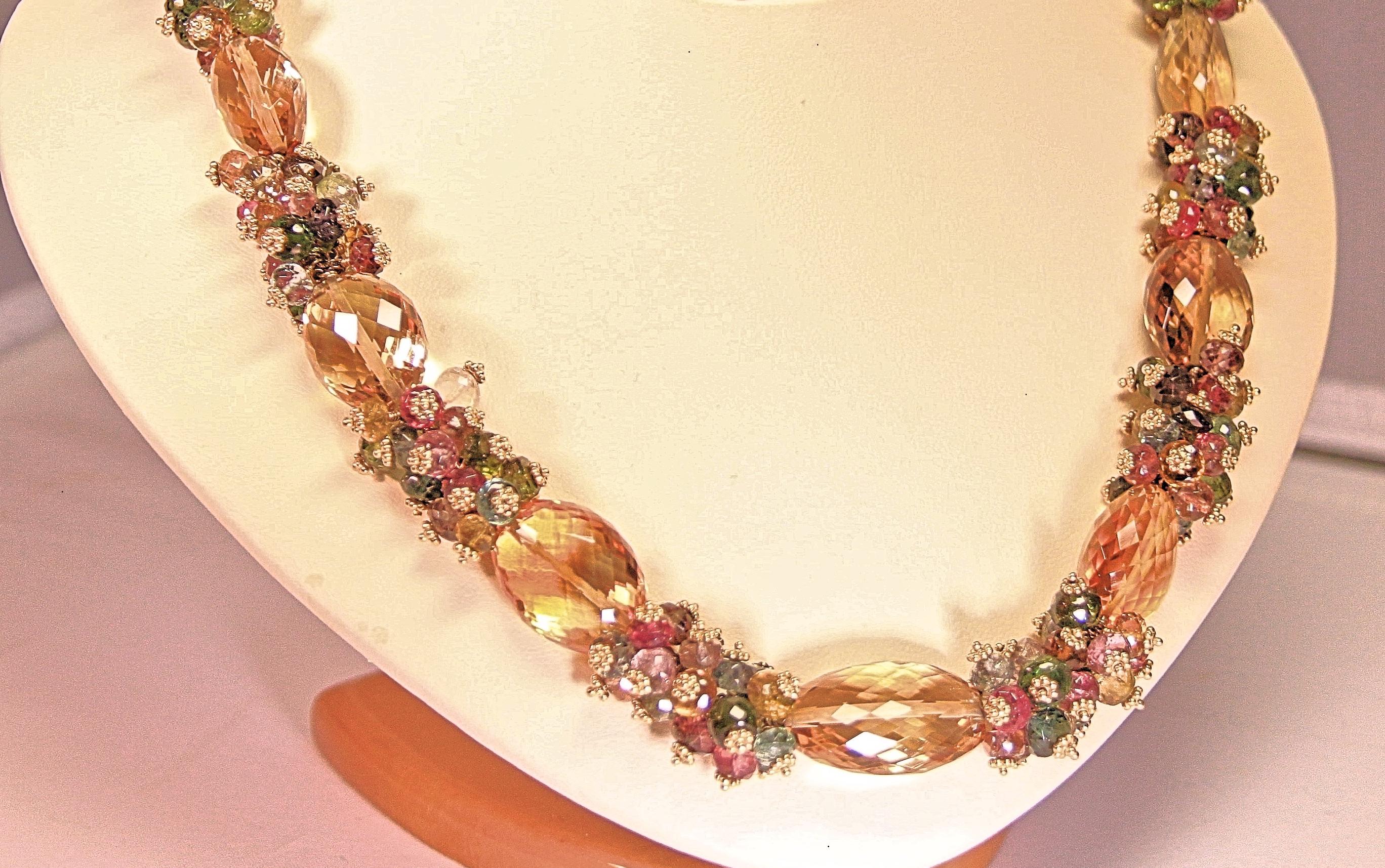 This necklace is a multi-colored semiprecious stone necklace that was designed by Marya Dabrowski.  The stones are yellow citrines and blue, green, pink, purple tourmalines.   The stones are beautiful faceted colors with an 18 karat yellow gold