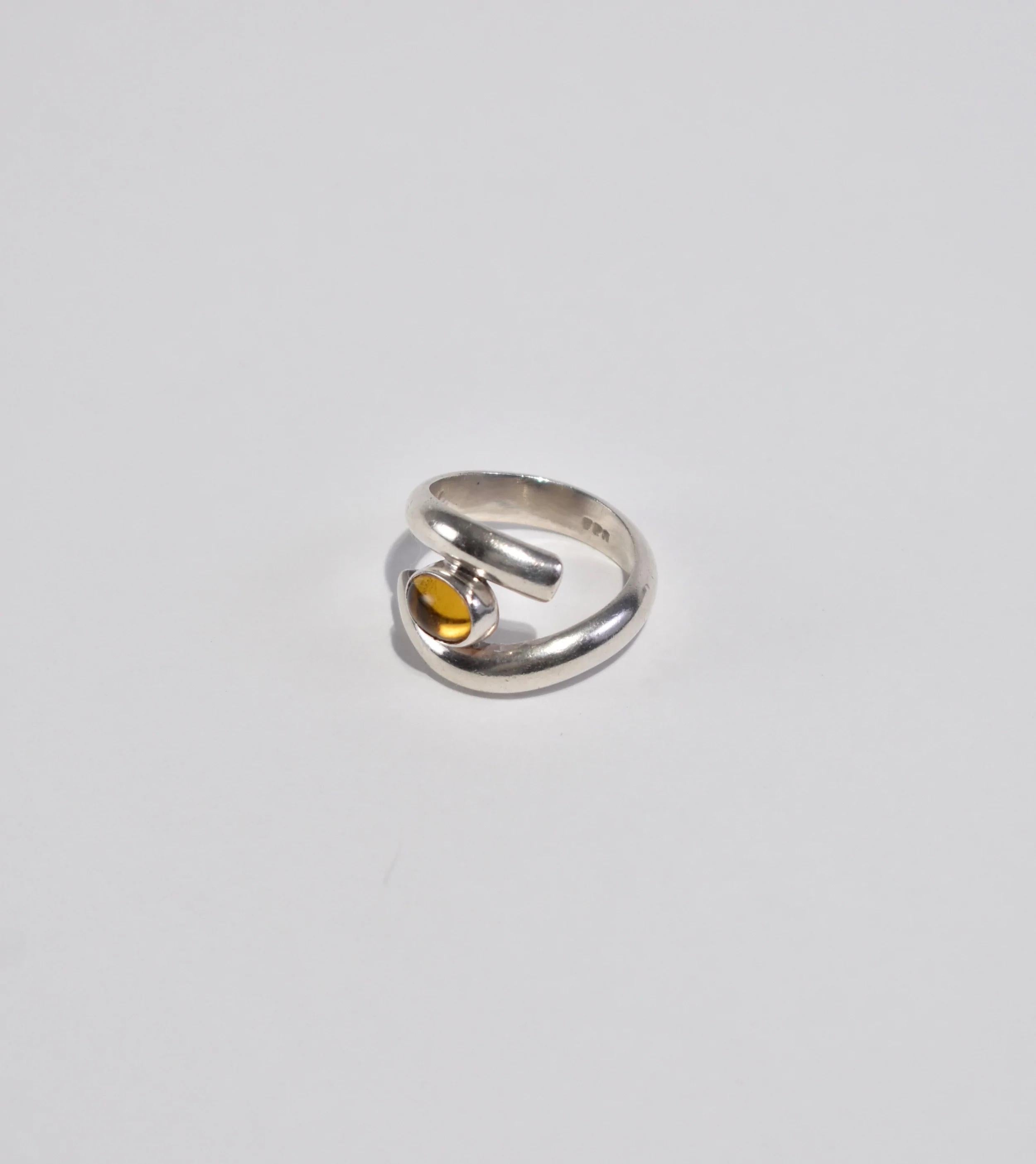 Stunning vintage sterling ring with wrap design and citrine cabochon detail. Stamped 925.

Material: Sterling silver, citrine.