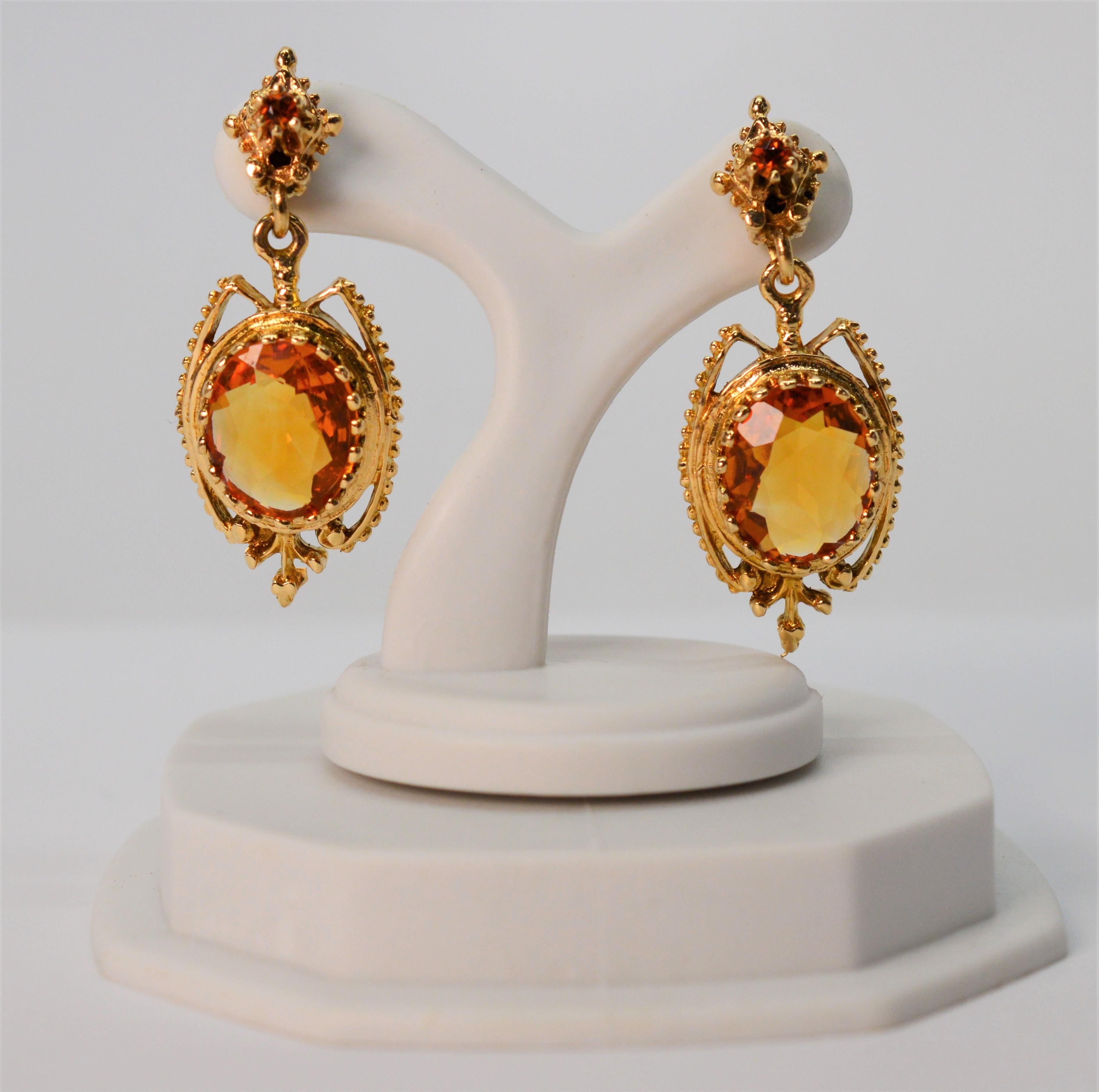 Warm honey colored citrine stones are elegantly framed in an antique style fourteen karat 14k gold setting to create these romantic drop earrings. Facet cut oval in shape, the two lovely 8x11mm gem stones have a total weight of 2.4 carats. For