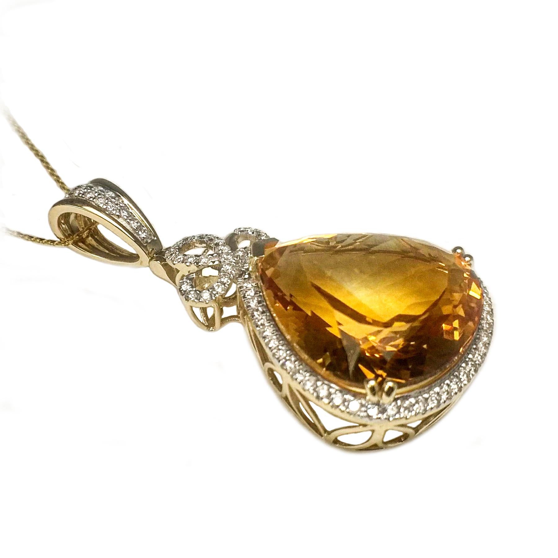 Stunning citrine and diamond pendant. Pear shape faceted, transparent, high luster, golden honey yellow 30.91 carats citrine encased in basket mounting, with one split prong and four bead prongs, framed in round brilliant cut diamonds along with