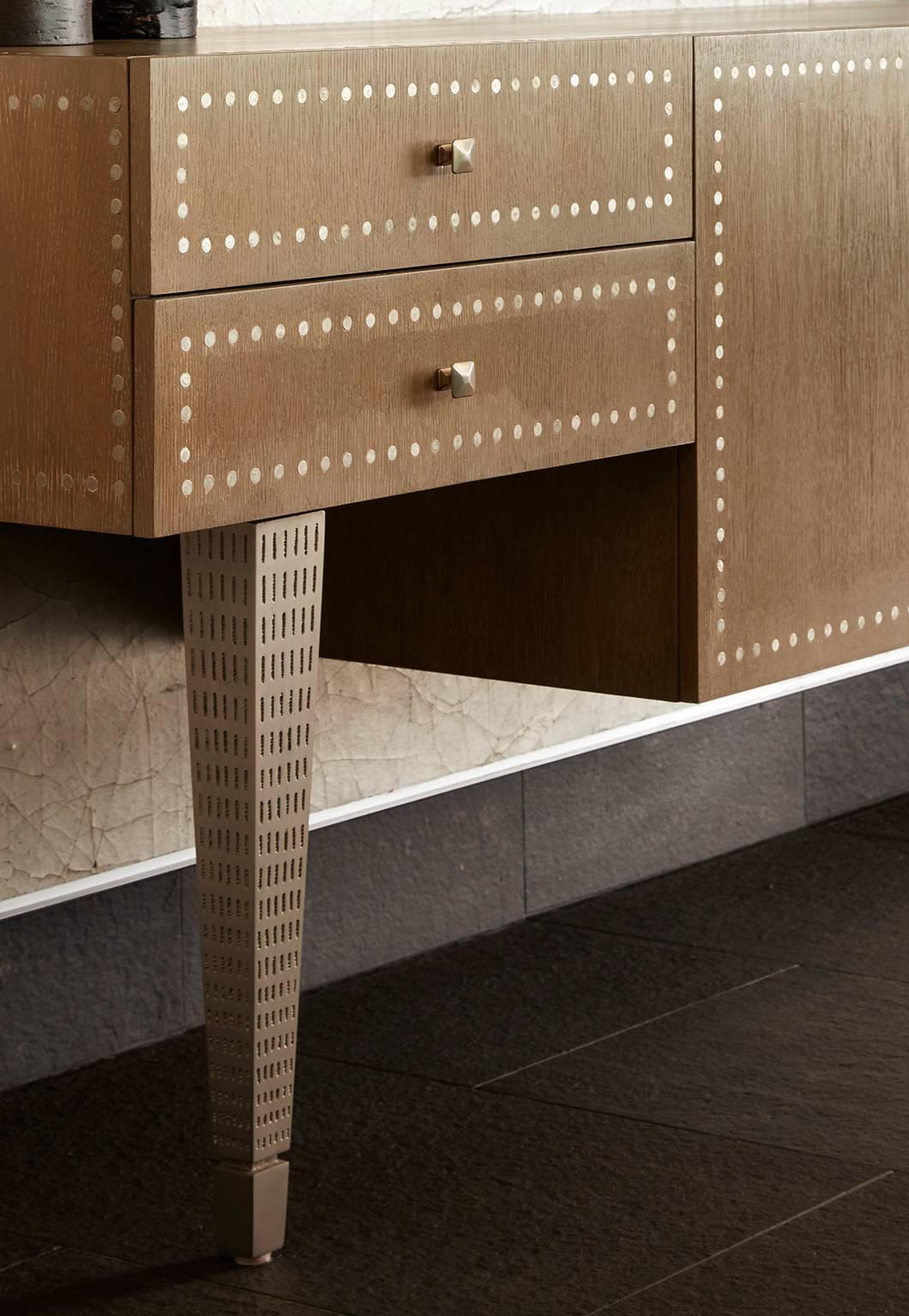 Shown in silver oak finish with pitted white bronze legs, nailhead detail, touch latch doors and adjustable shelving.
The city console by Bradley Bayou home can be customized.