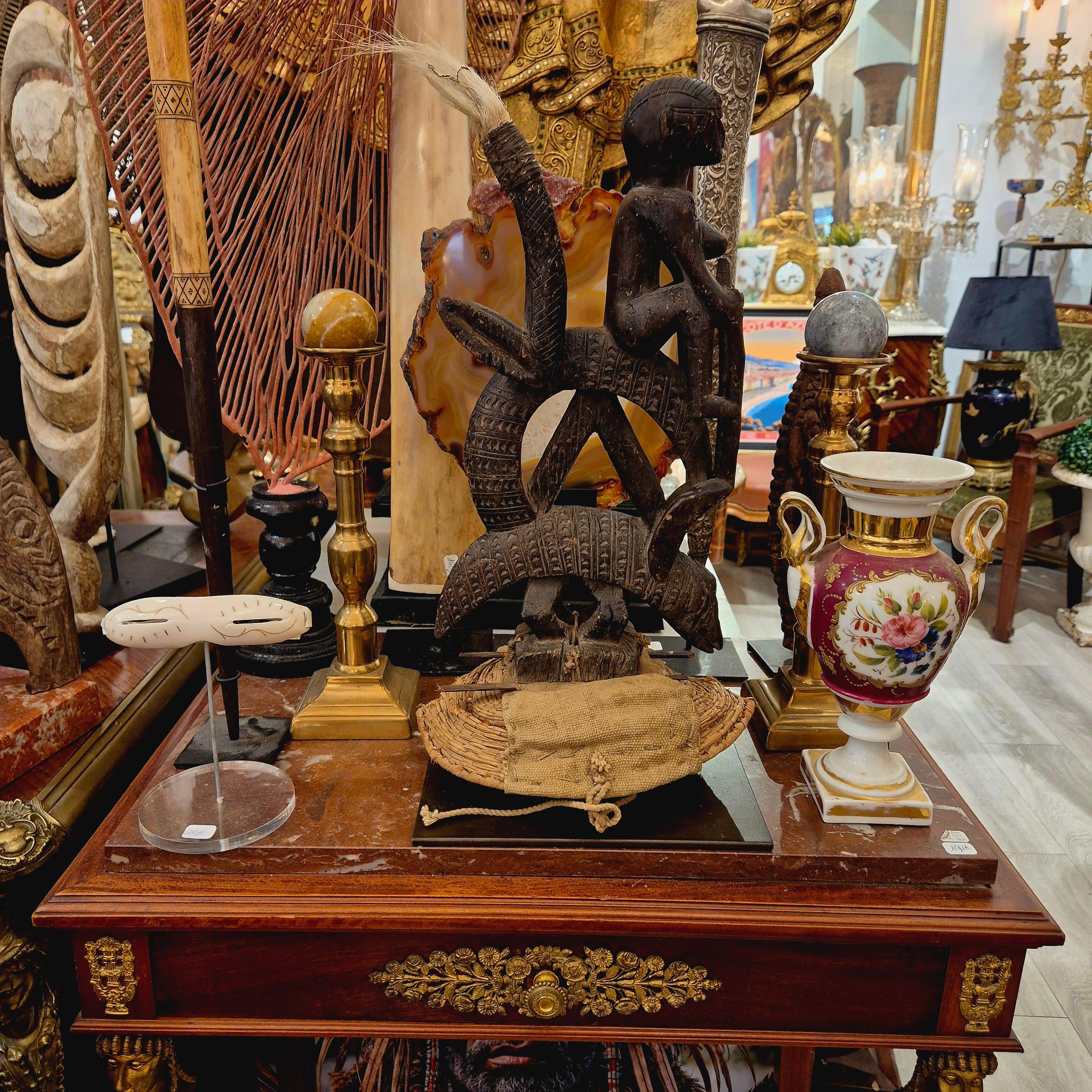 A very pleasing Ciwara crest, singularly small and accompanied by its original headdress, depicting a stylized antelope leaning on a pangolin. The antelope is ridden by a woman, and white horsehair has been added to the tips of the horns. The piece