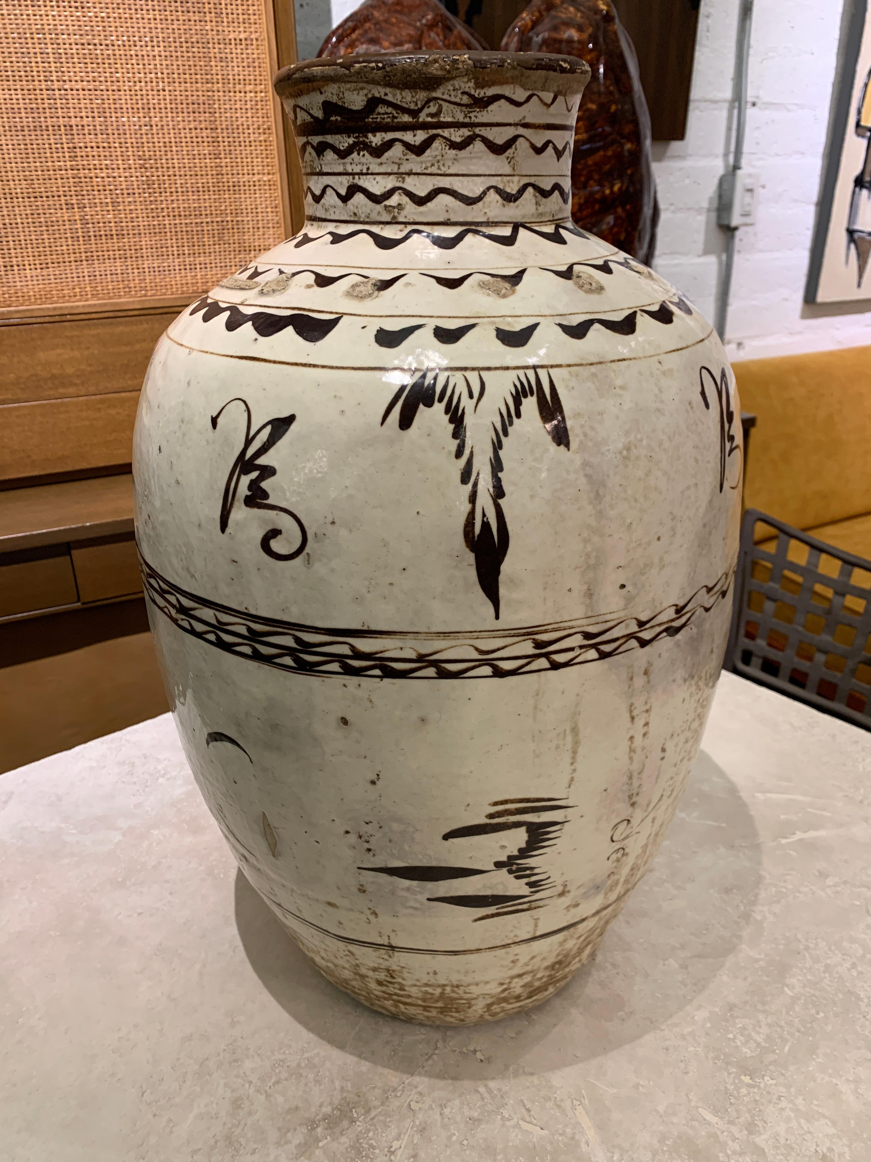 A Cizhou decorated stoneware wine vessel likely late 19th century but possibly earlier. Nice paint and decoration, with good scale. There are numerous imperfections particularly around the rim and in general all over, please see the detailed photos.