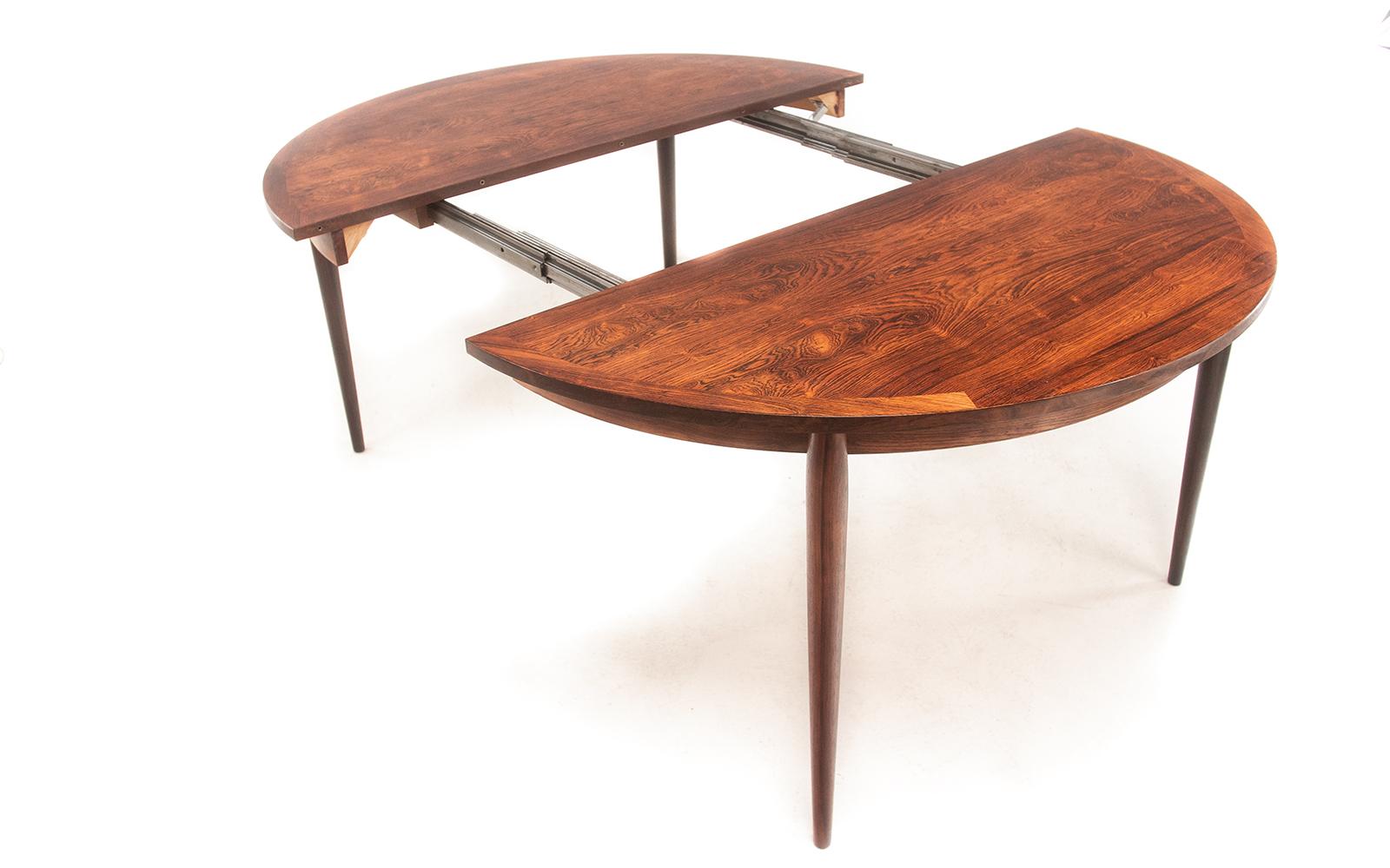 Mid century Danish ‘Rosengaarden’ rosewood extendable dining table seats 8-10

This 1960s rosewood dining table has rounded ends, transitioning from a round table to an oval after the extension leaves have been added. They are supported on