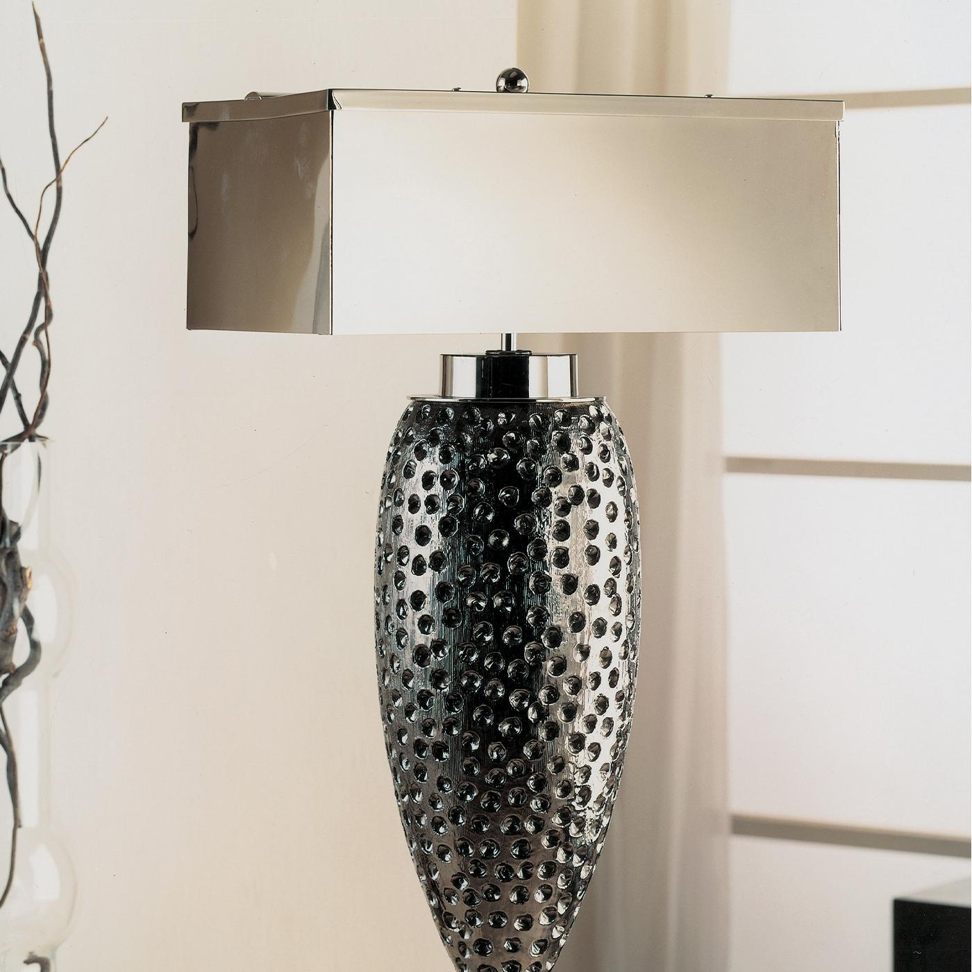 The hand-engraved and silver plated Majolica body of this table lamp gives off an almost sea-creature look with its mottled finish. The lamp has chrome brass detailing, rests on a black marble base, and has a chrome-plated, rectangular-shaped brass