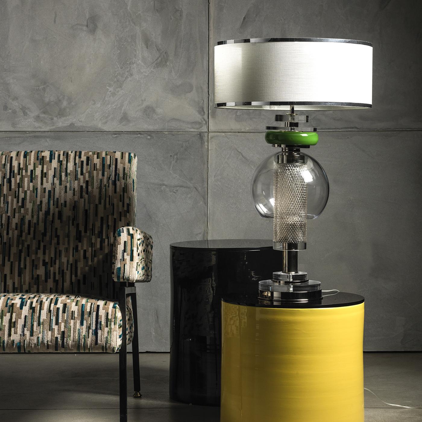 This crystal table lamp is composed of green Majolica pottery, nickel-plated brass and plexiglass. Its double lampshade features a silver woven-fabric exterior with an interior in green silk. Its sophisticated minimalism displays a surprising visual