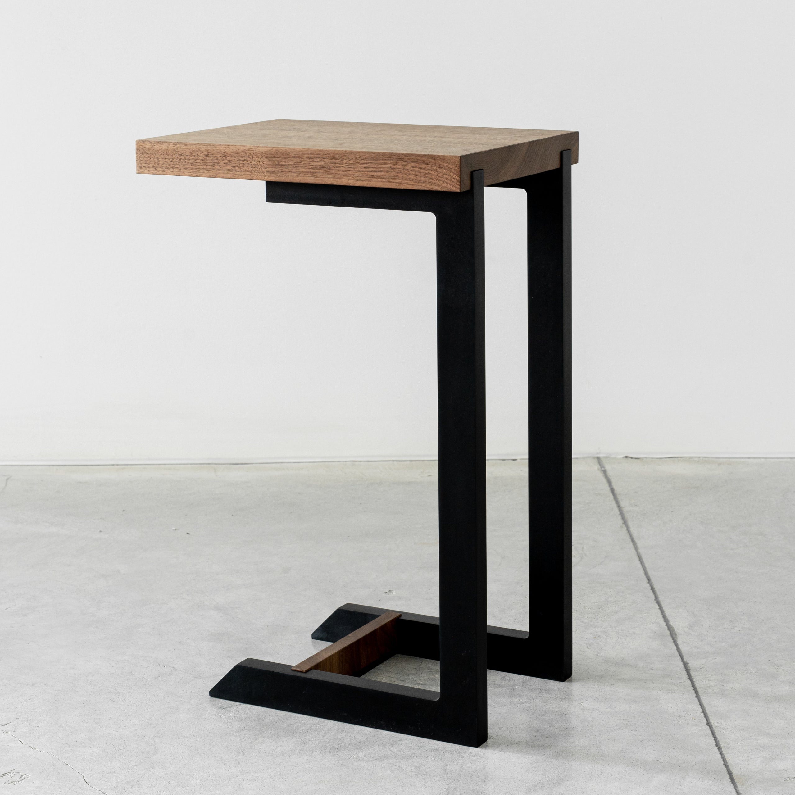An end table that is always there when you need her, pulled up to a sofa for a cocktail or cup of tea, much like a best friend. The Clair Black end table was designed in a dramatic silhouette of matte black using recycled paper composite, shown in a
