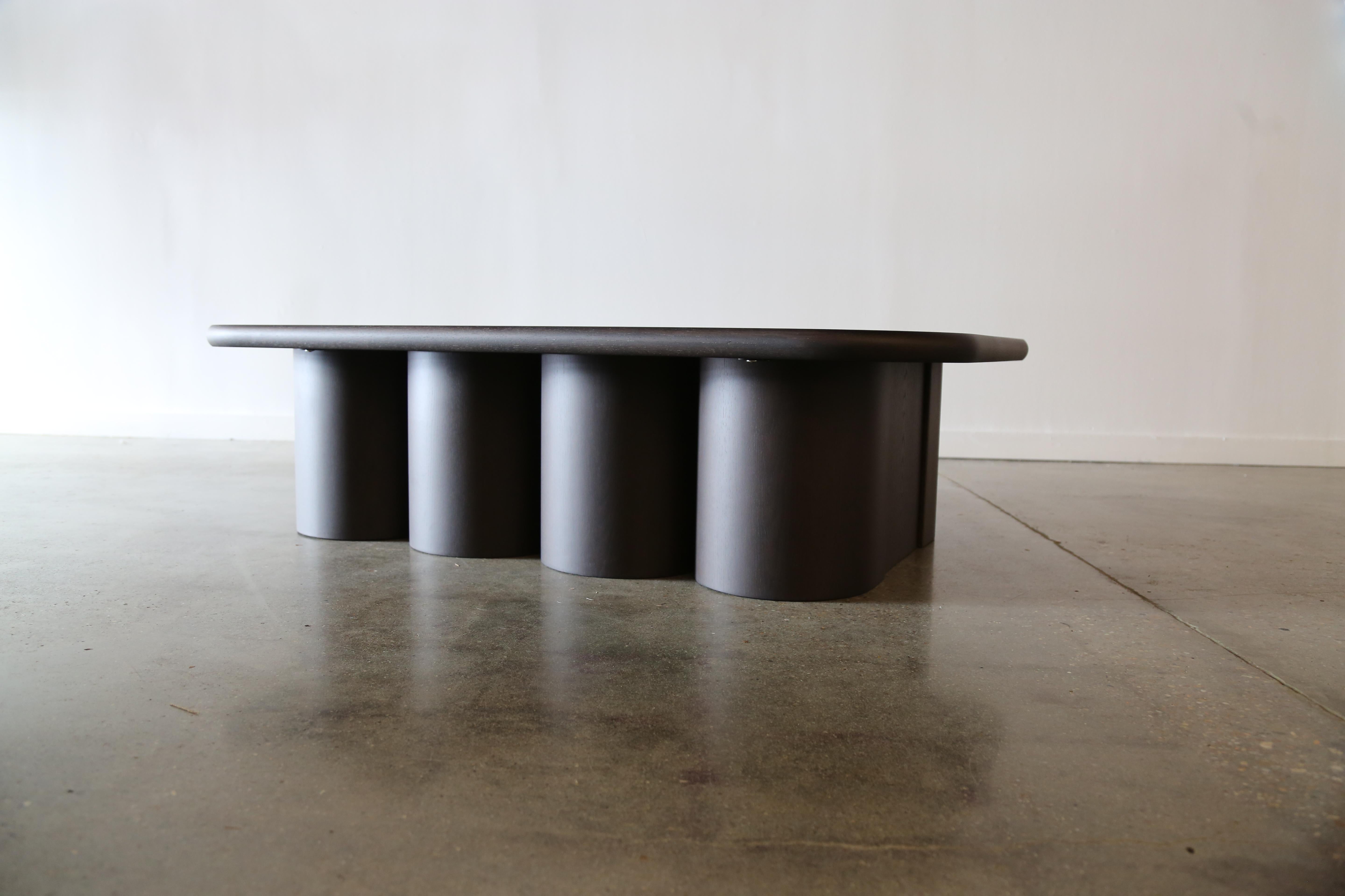 Une table basse contemporaine conçue par Philip Goold de Virginia Beach. Un plateau en chêne blanc massif avec une finition chocolat foncé. Le plateau, avec ses angles arrondis et ses bords doux et arrondis, fait allusion à la base arrondie qui