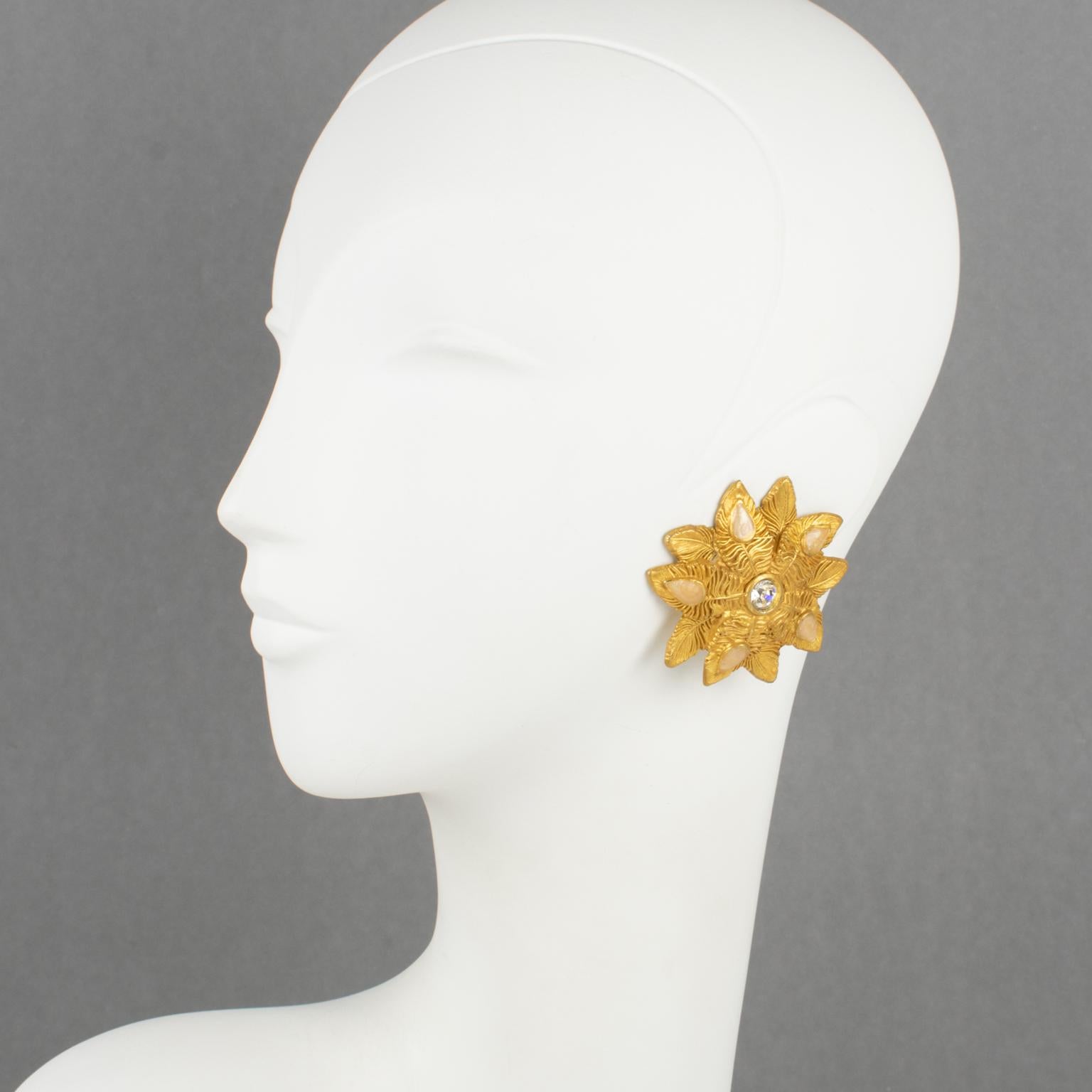 Claire Deve, Parius, a conçu ces spectaculaires boucles d'oreilles à clip dans les années 1980. Elles présentent une forme florale en métal doré, entièrement ciselé et texturé, surmontée de cabochons en forme de larme en émail rose clair perlé, et
