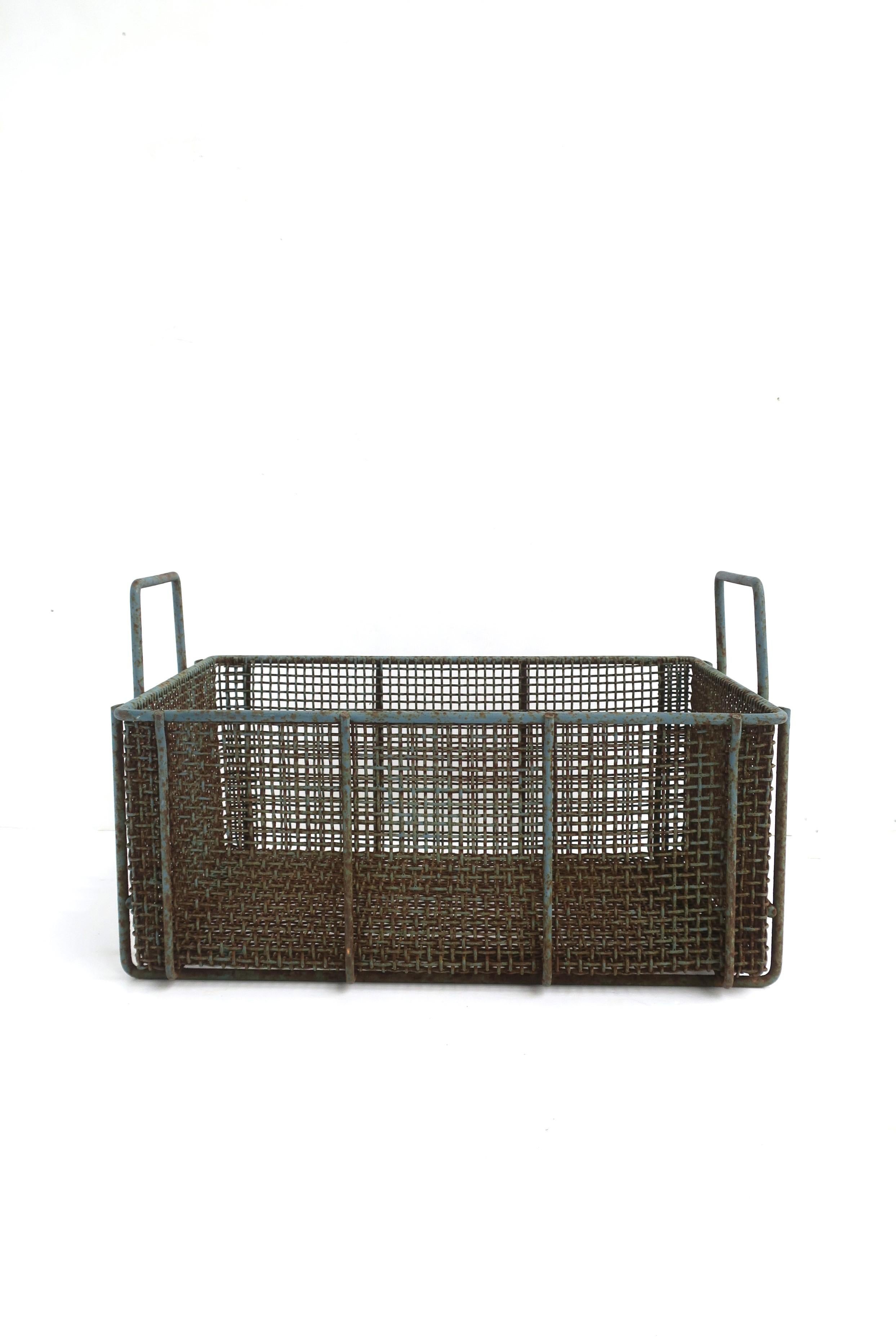 A substantial and well-made iron basket with a blue-gray hue, circa mid-20th century or earlier. Basket is rectangular with handles, likely used for gathering and holding fresh clams or other shellfish from the deck of clam boat. Today, it can be