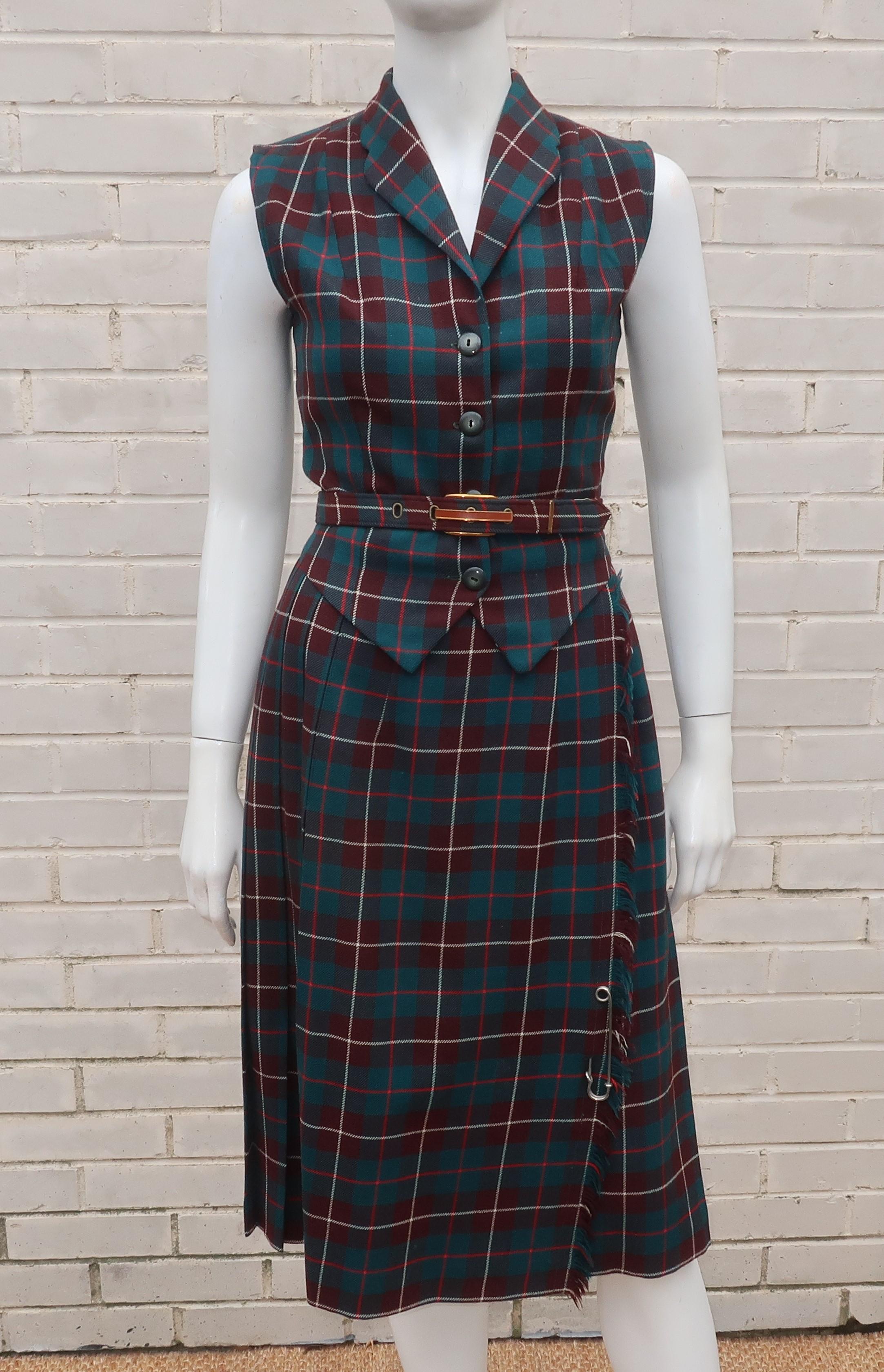 Get your tartan fix with this 1950's Clans of Scotland two piece vest and skirt in a wool plaid with shades of brown, teal green, red and white.  The slim fitting vest buttons at the front with an iridescent light brown lining and the classic