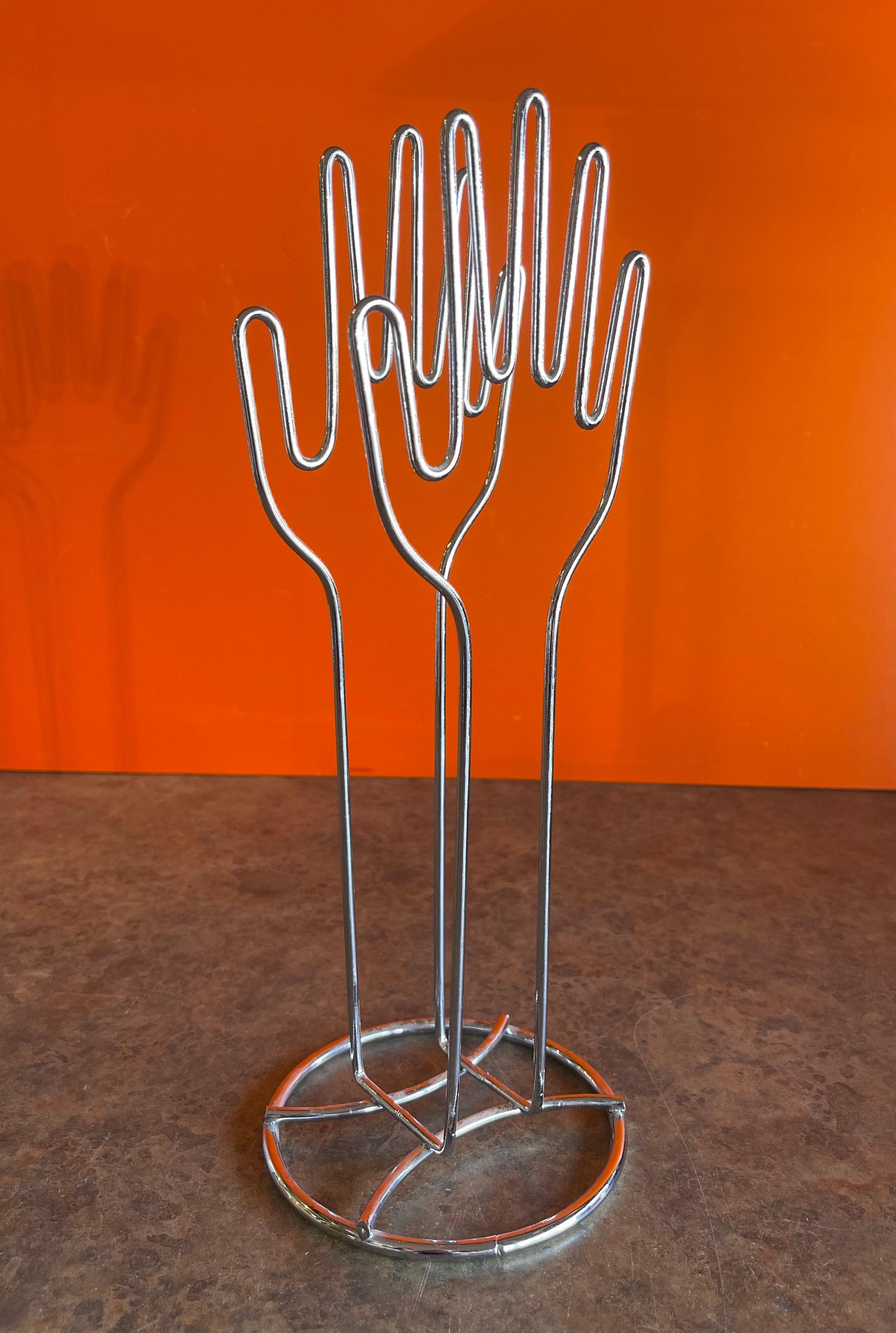 Nice clapping hands wire sculpture model in chrome that can double as a paper / folder holder, circa 1980s. The piece is 13.5