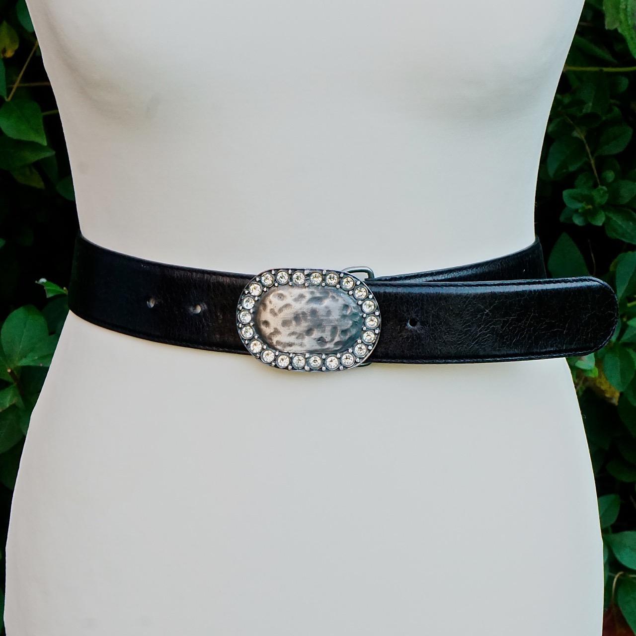 Schwarzer Ledergürtel von Clara Perri mit einer schönen ovalen, silberfarbenen Schnalle, die mit klaren Kristallen besetzt ist. Der Gürtel ist verstellbar, von einer tragbaren Länge von 103cm / 40.5 inches bis 90cm / 90.5 inches  35.4 Zoll, und die