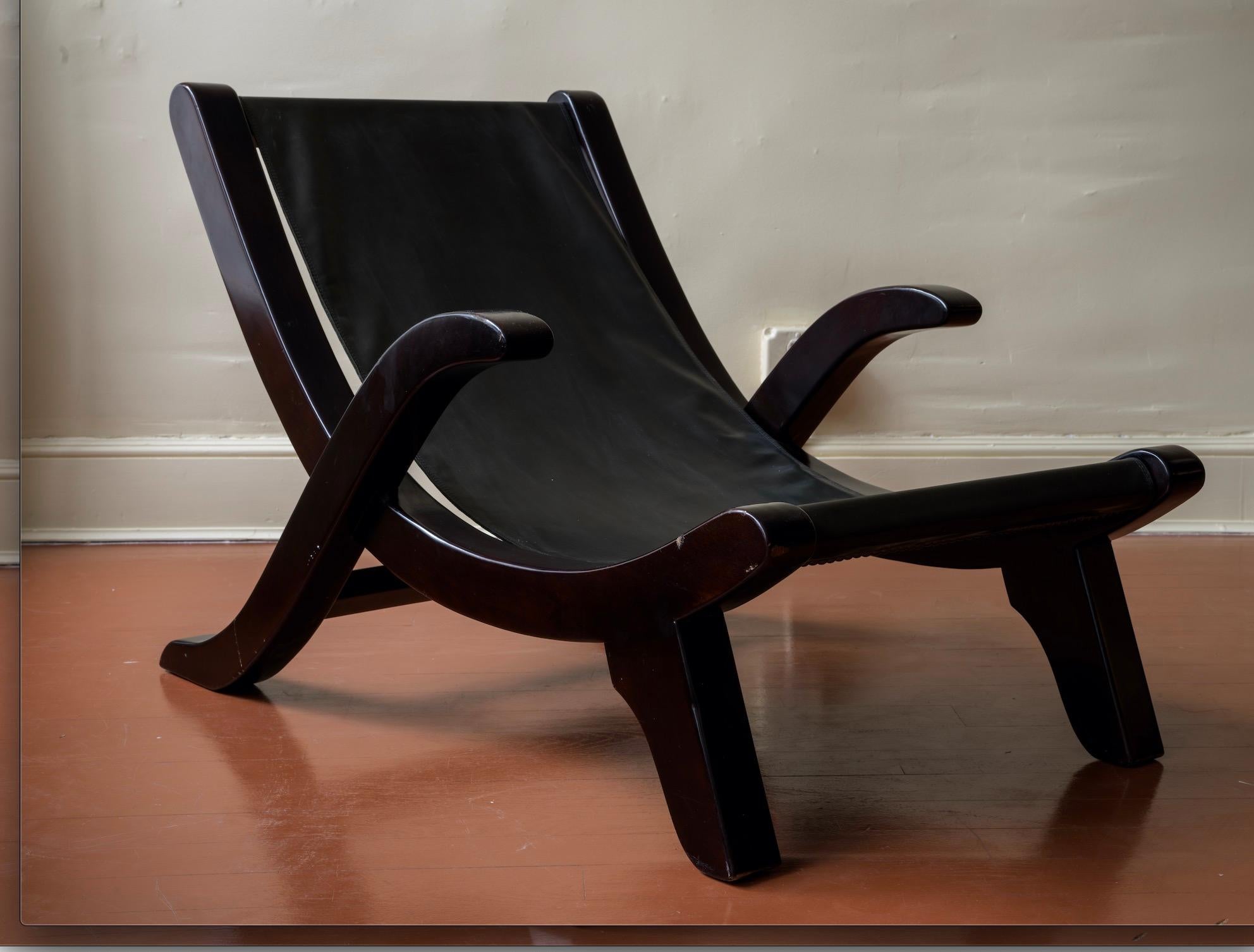 Una silla tipo cabestrillo de mediados de siglo con base lacada en negro y asiento de cuero recién tapizado al estilo de la pionera diseñadora de muebles e interiores de origen cubano Clara Porset.
