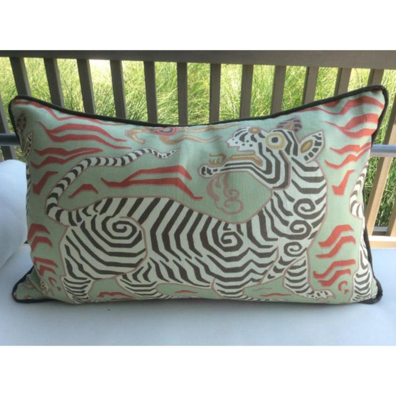 Fabuleux lin imprimé de Clarence House. Tibet Dragon, céladon, est un lin imprimé représentant un dragon stylisé sur un fond vert tendre. Les couleurs accentuées sont le saumon et le marron foncé. Cordonnées et doublées d'un lin brun chocolat