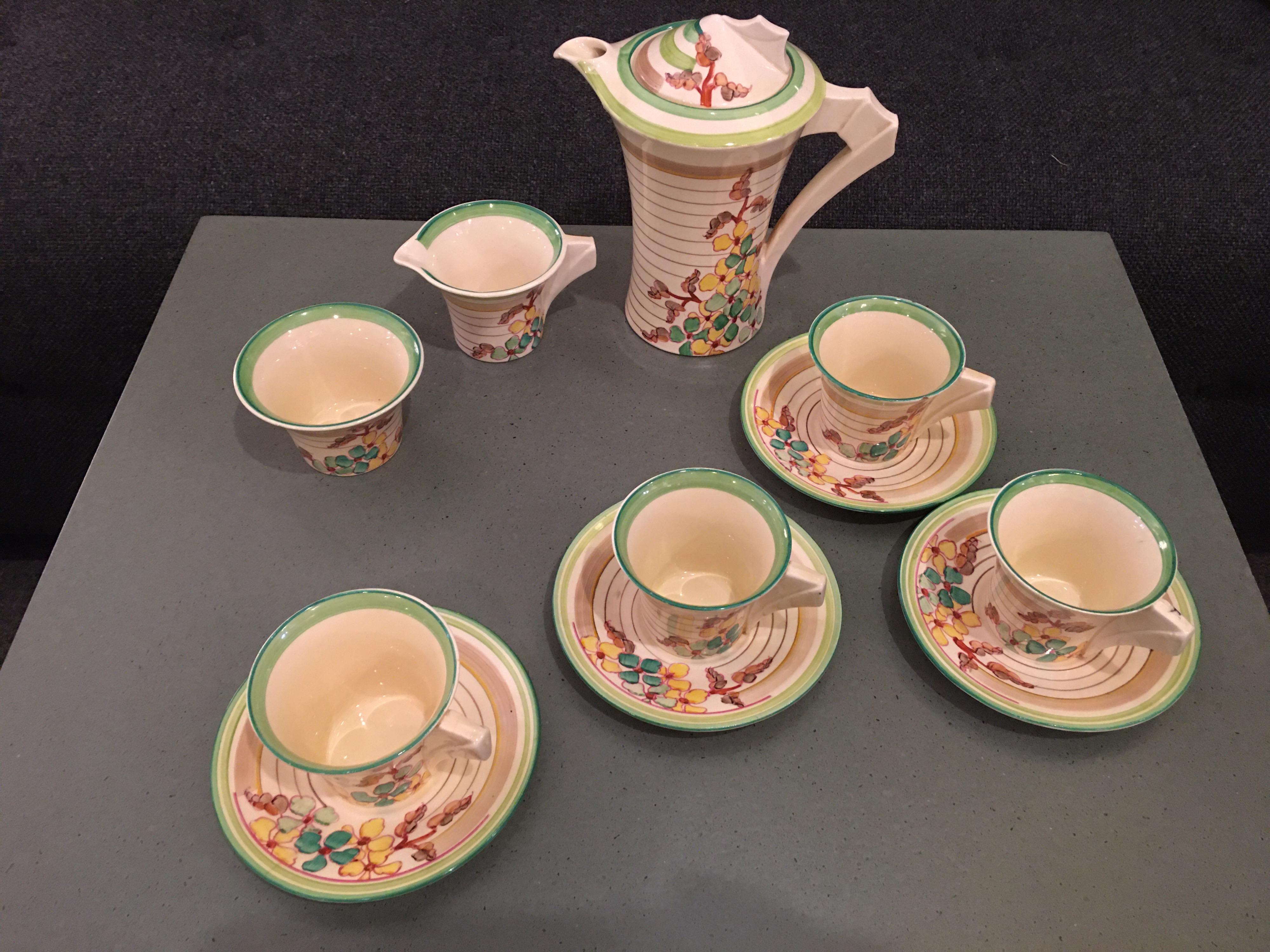 Clarice Cliff hand painted bizarre ware, marked made in England and Wilkinson England. Pattern is Green Hydrangea. Set includes coffee pot, cream and sugar bowls, 5 saucers and 5 cups. A few minor chips to rims etc. One cup has a hairline and coffee