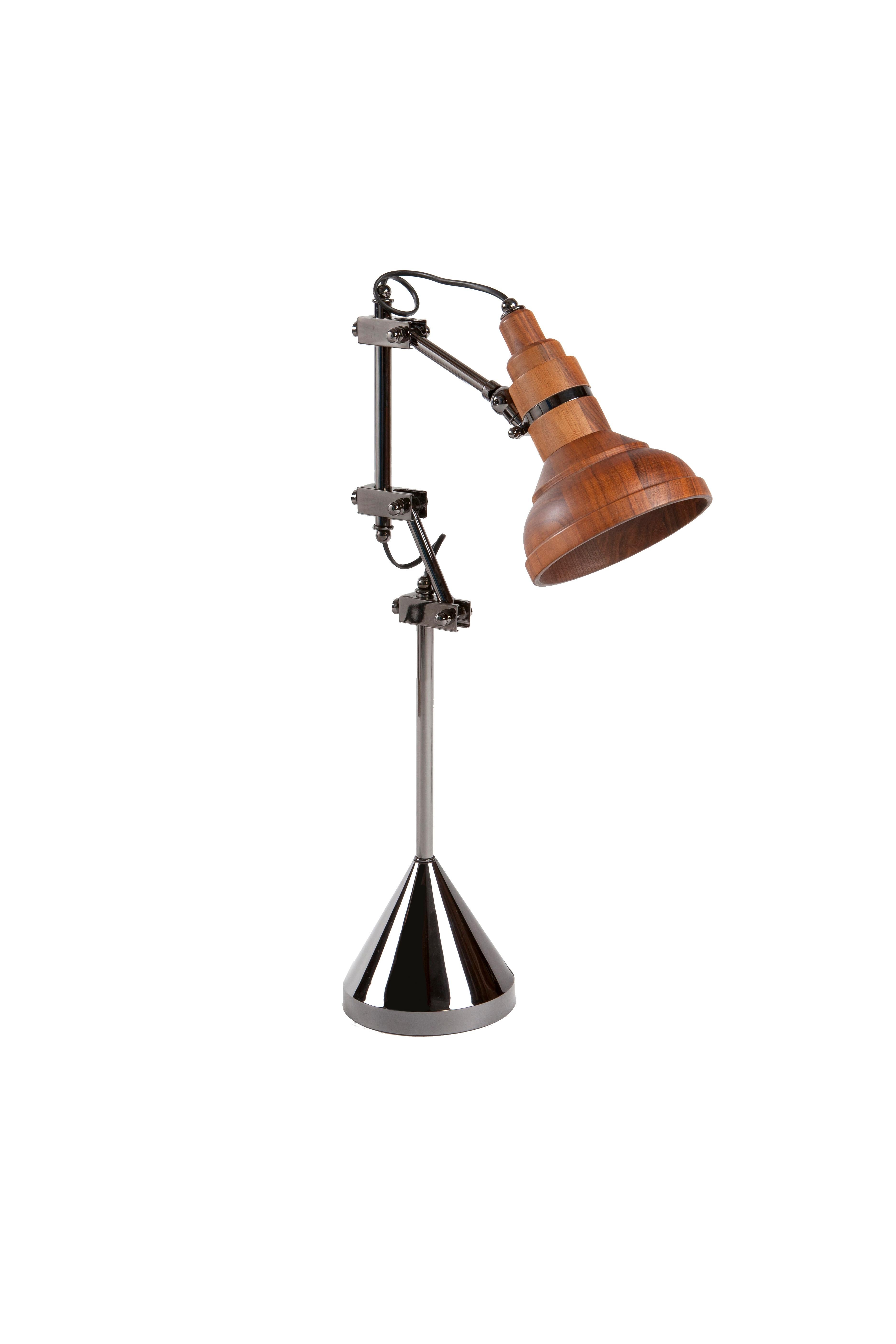 iluminación de Kontra.
La lámpara de sobremesa de metal con cabeza de madera proporciona iluminación con un aire moderno de mediados de siglo.
Lámpara de escritorio de madera, luz de estudio estilo años 70.