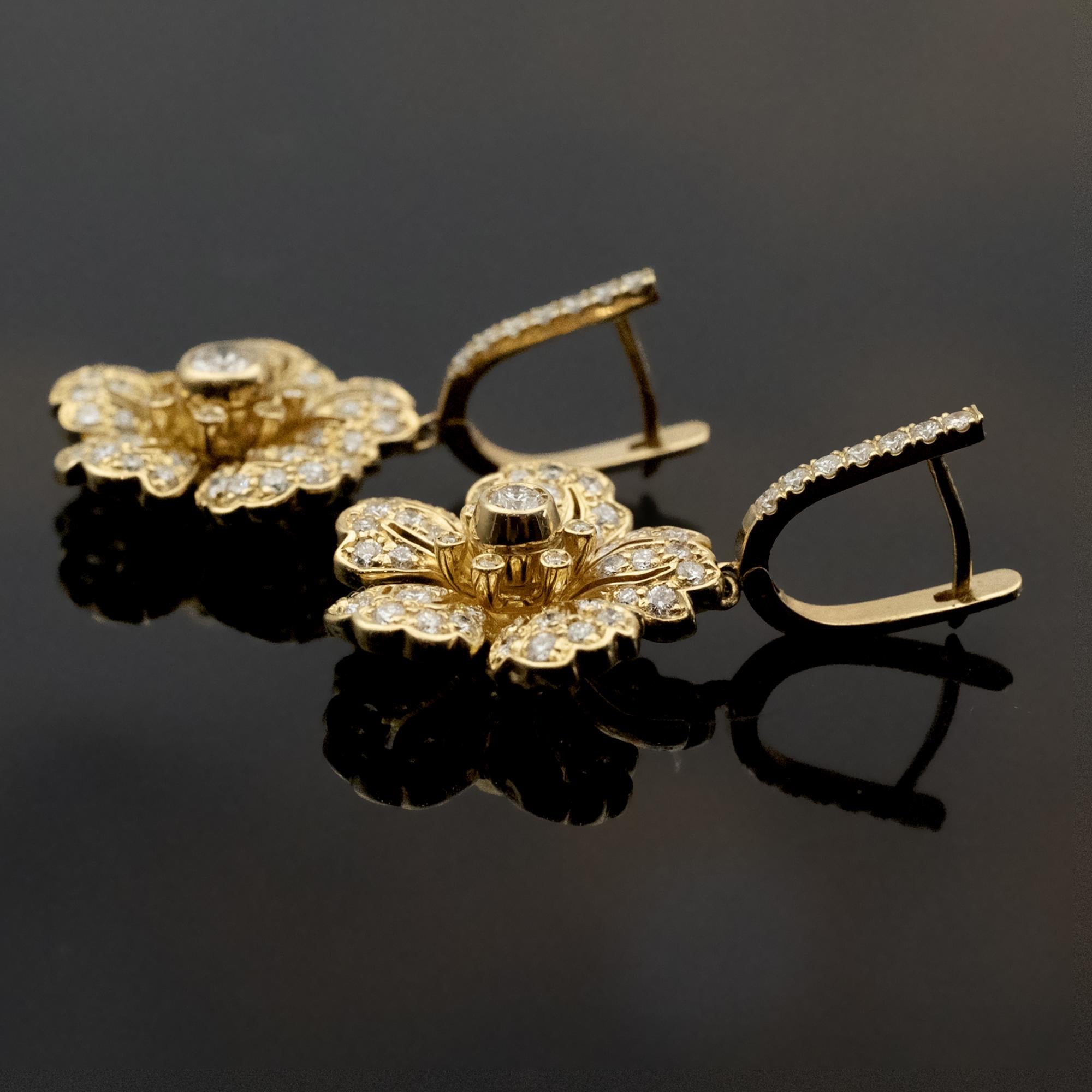 Cette paire de boucles d'oreilles raffinées en or jaune 18 carats, conçues comme des fleurs stylisées serties de diamants blancs. Chaque pétale est délicatement façonné et incurvé pour rehausser l'éclat des pierres. Cela permet de créer une forme