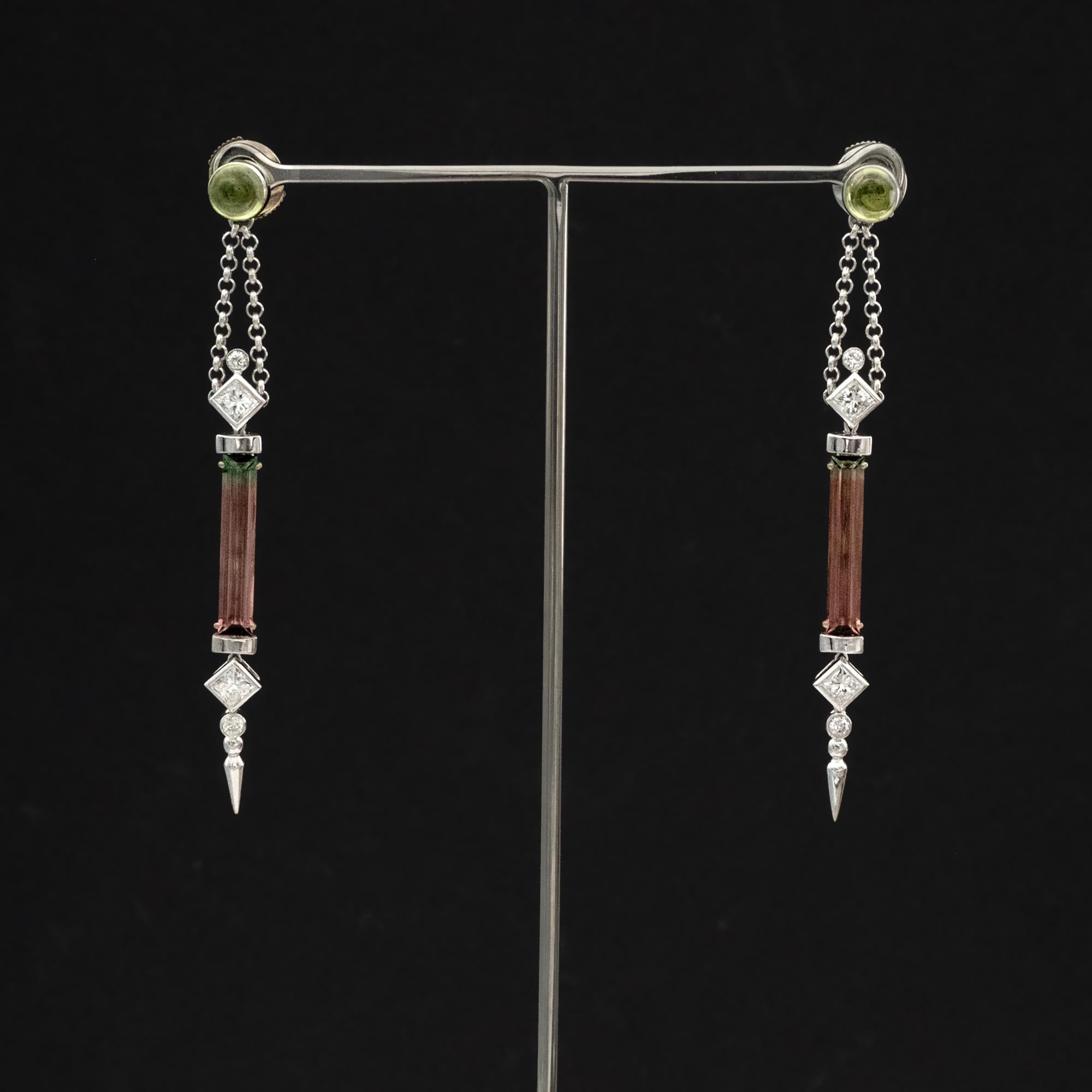 Diese Ohrringe aus 18 Karat Weißgold zeigen eine elegante, langgestreckte Silhouette, die ein seltenes Paar zweifarbiger Turmaline im Baguetteschliff umgibt. Jeder Stein weist einen natürlichen Farbverlauf auf, beginnend mit einem lebhaften grünen