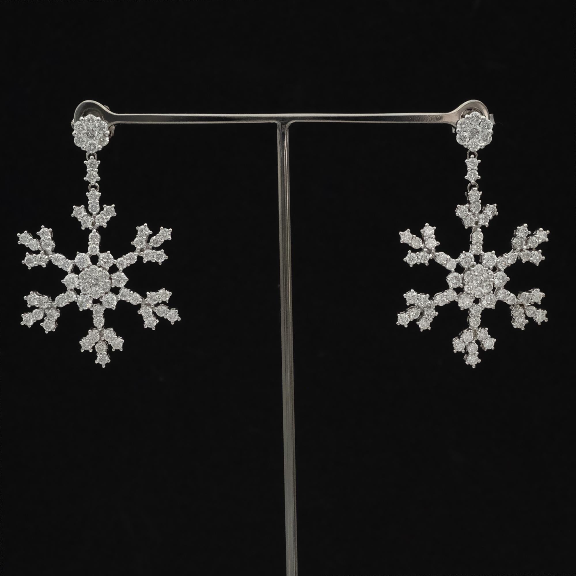 Questi lunghi orecchini di diamanti reinterpretano la delicata geometria di un fiocco di neve o di una stella con una silhouette raffinata e moderna. Realizzato in oro bianco, ogni orecchino si estende in una linea sottile e allungata che sfocia in