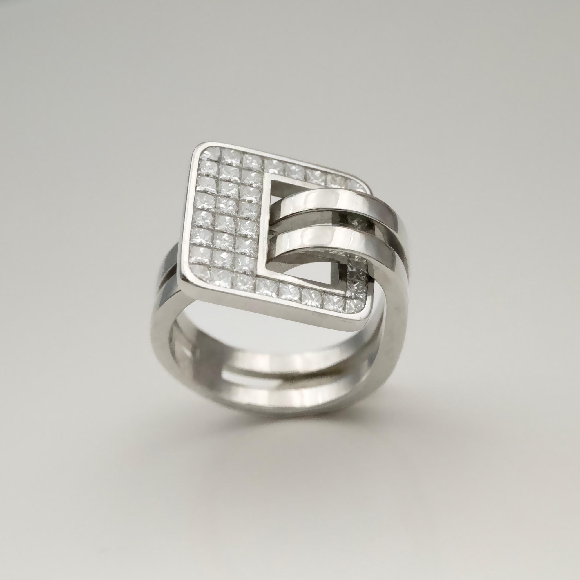 Dieser von Claris.A angebotene Ring ist aus 18 Karat Weißgold gefertigt und weist ein starkes geometrisches Design auf. Das Oberteil ist als quadratisches Element geformt und mit Diamanten im Prinzessschliff in unsichtbarer Fassung (serti