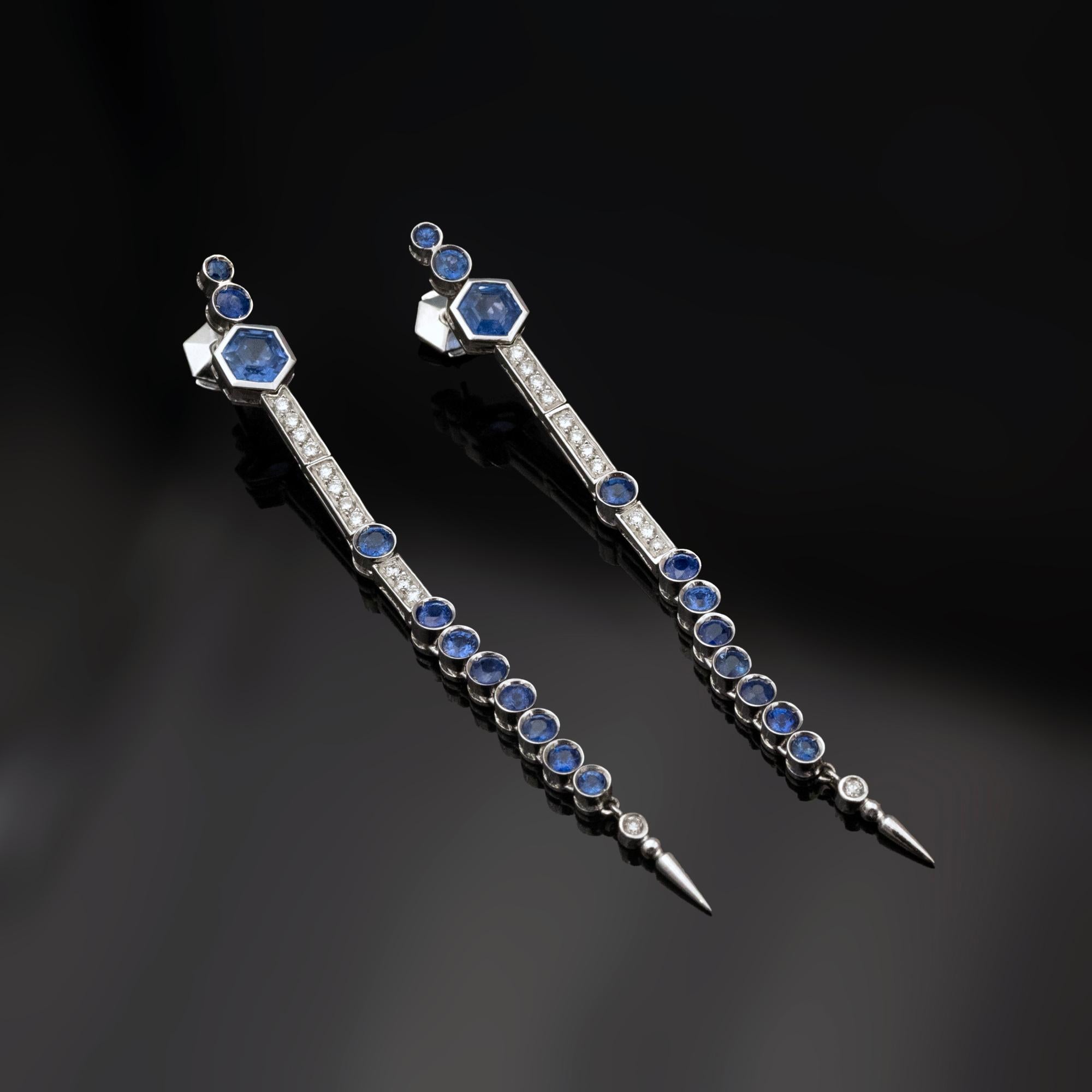 These unique long dangle earrings feature a total of 4.62 carats of vivid blue Sri Lankan (Ceylon) sapphires, Known for their vibrant color and brilliance. Set in 18k white gold, the earrings are designed with hexagon-cut sapphires at the top (2.04