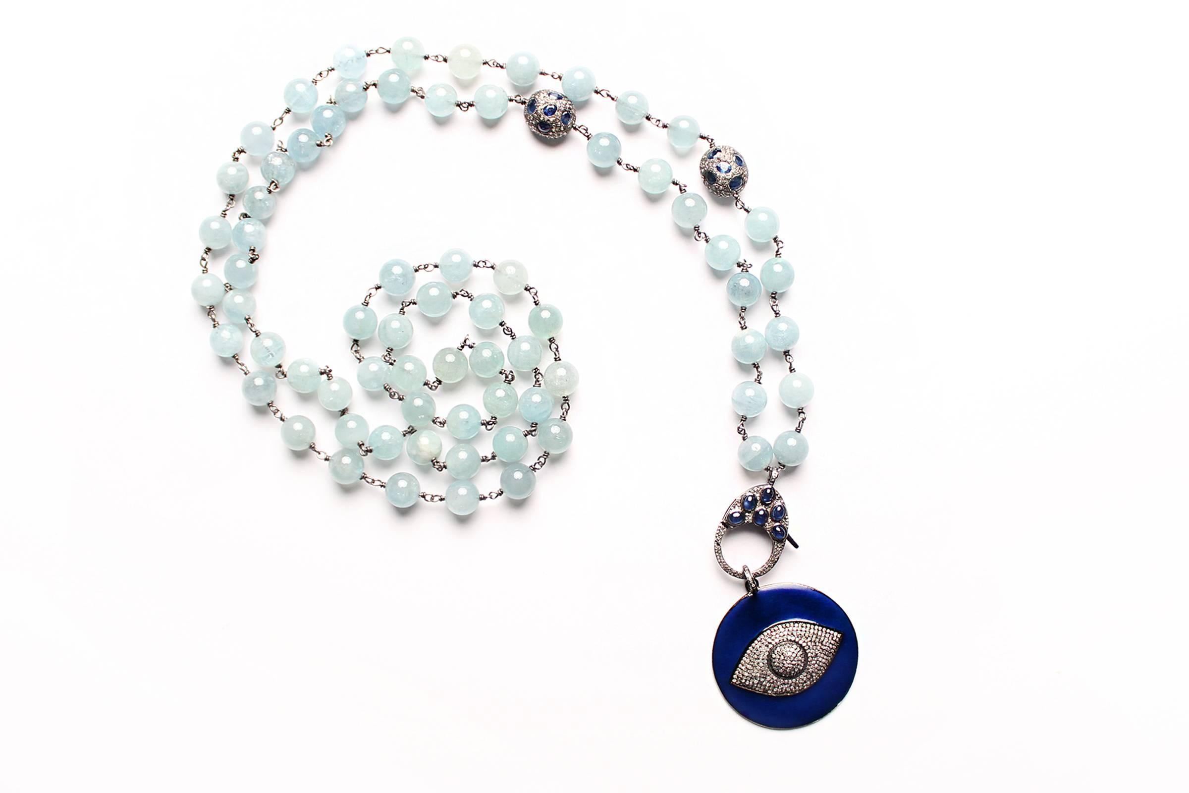 Beaded necklace made of aquamarine beads, silver, with diamond sapphire tumblers on silver. Royal blue enamel eye pendant with diamonds. 
