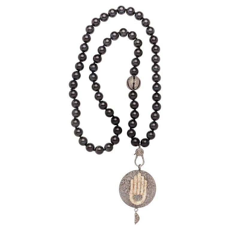 Black shiny onyx beaded necklace, with silver/diamond/enamel tumbler and diamond/silver clasp. Hamsa hand silver, gold plated, and diamond pendant with xs dangling wing charm on the bottom end. 