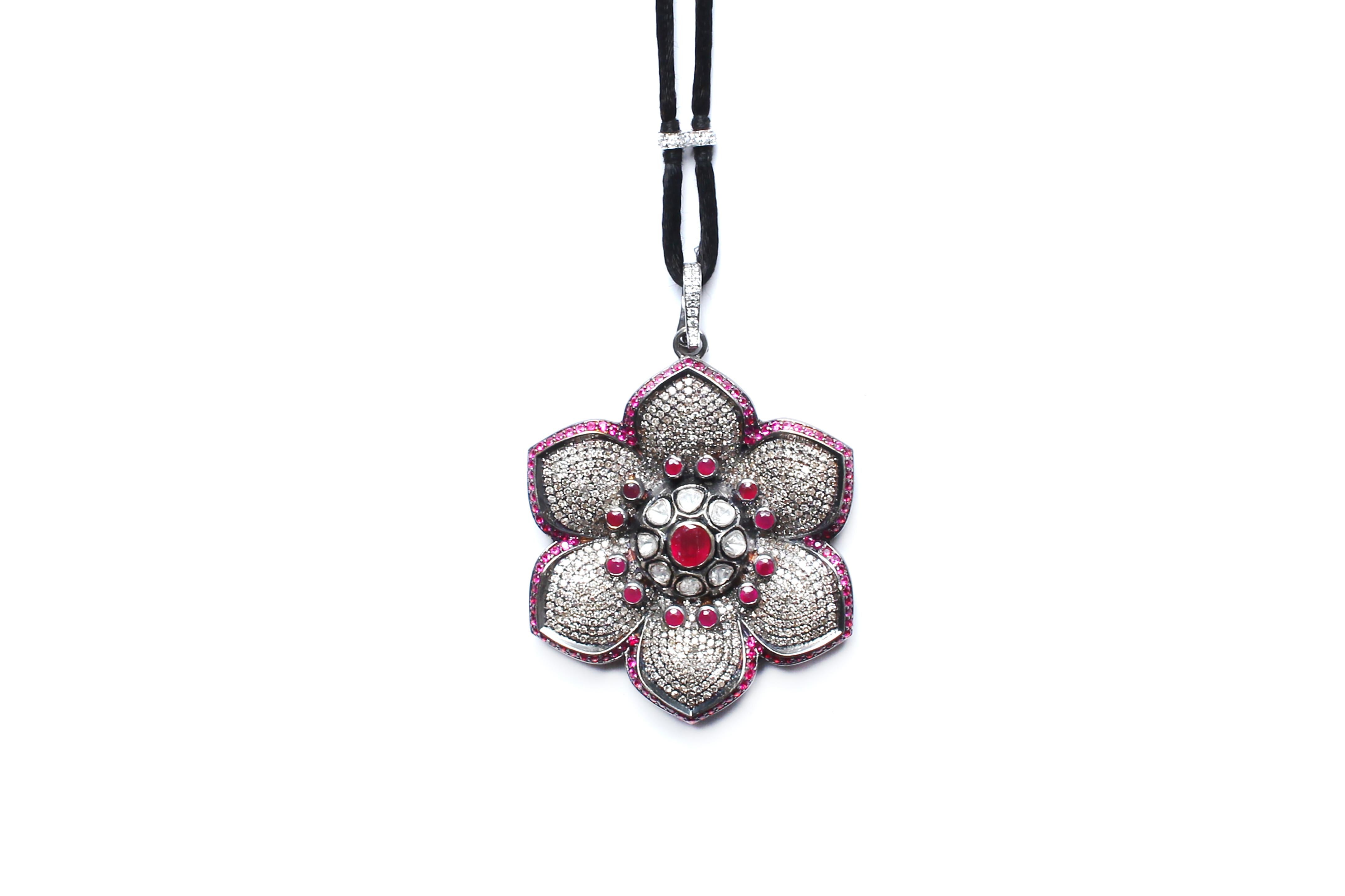Ruby, diamond, rose cut diamond, and silver flower pendant. Has a separate removable diamond and silver clasp. 

Adjustable suede, and diamond cord.