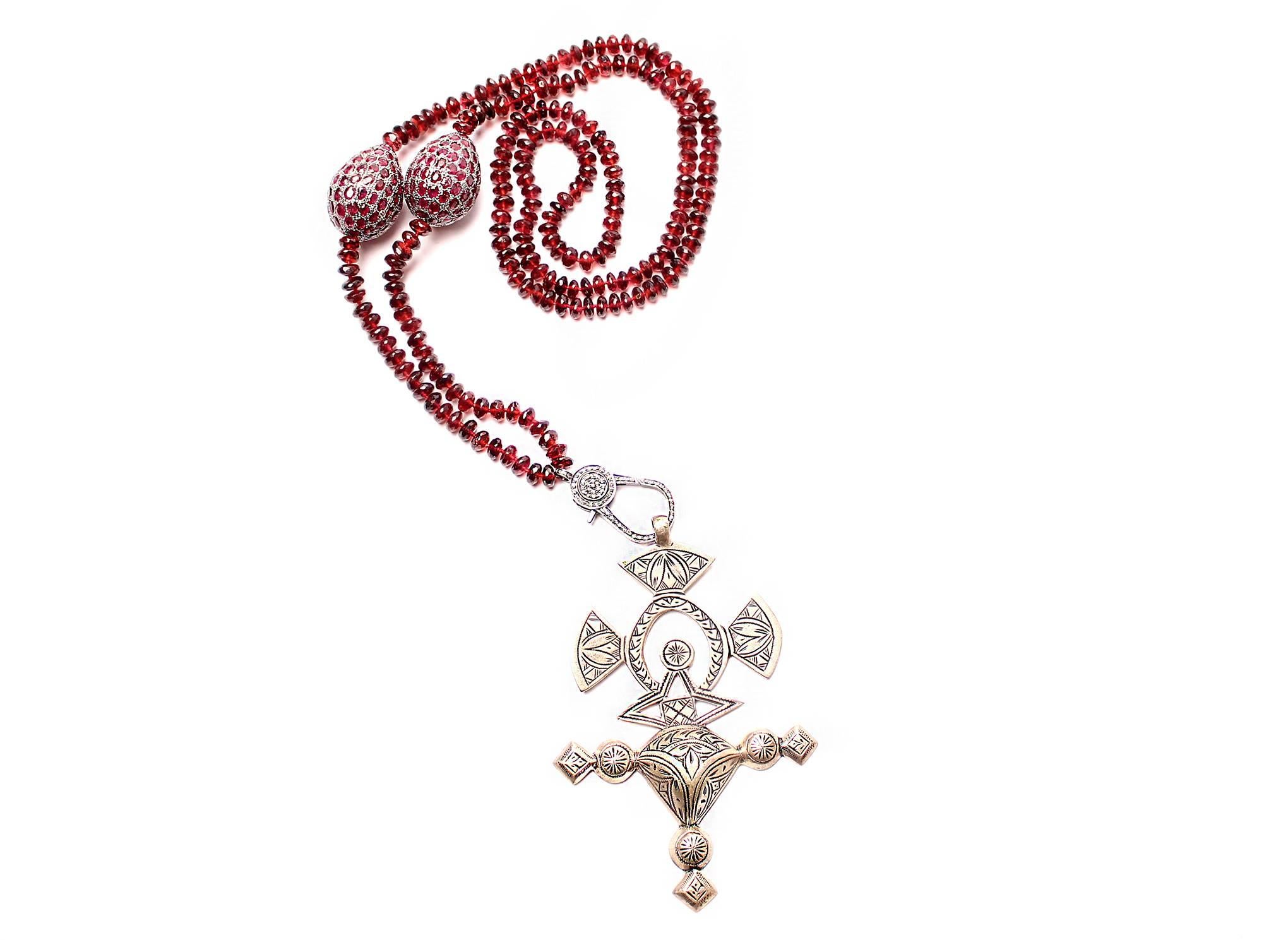 Necklace consists of garnet beads, with garnet and silver tumblers, a diamond clasp, with an antique silver Ethiopian cross pendant.