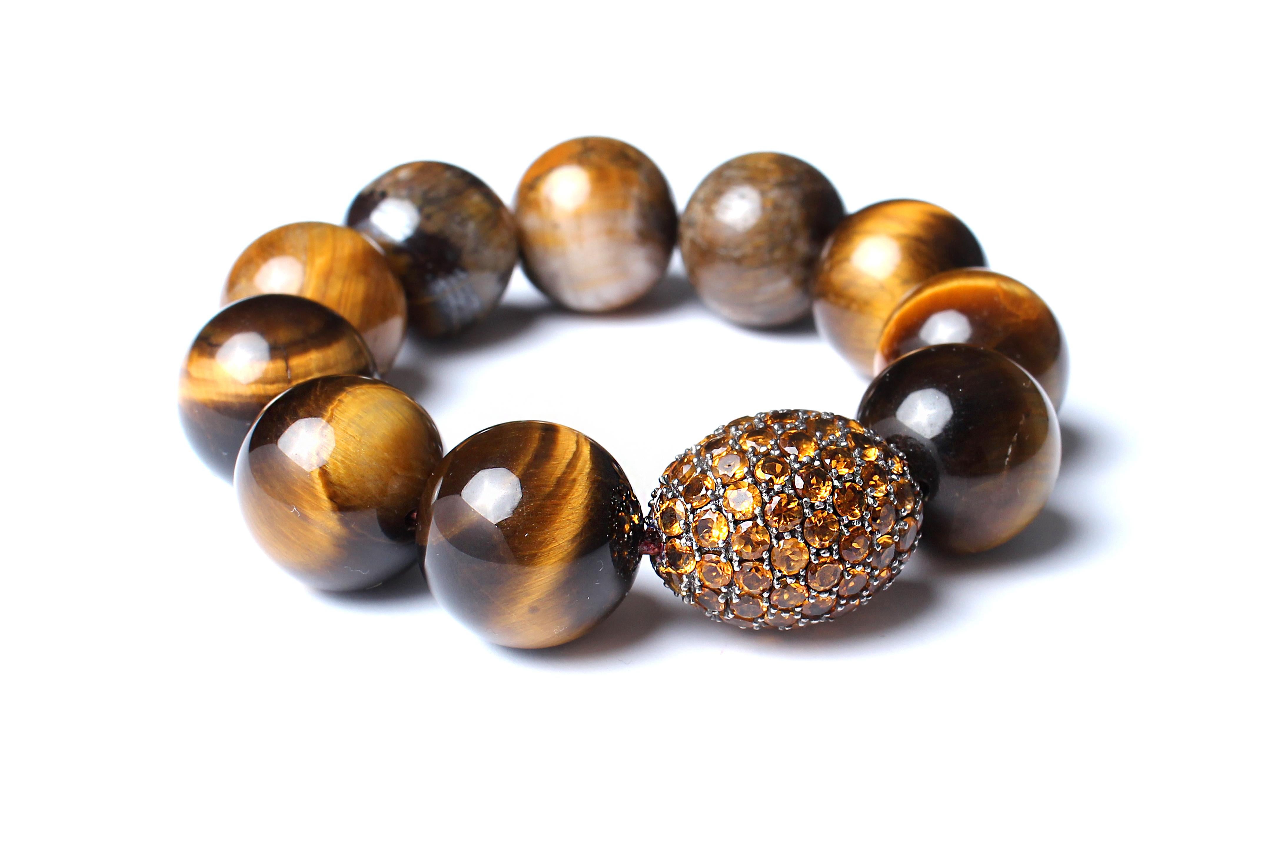 Elastic bracelet consisting of tiger eye beads (large), silver, and yellow sapphire.