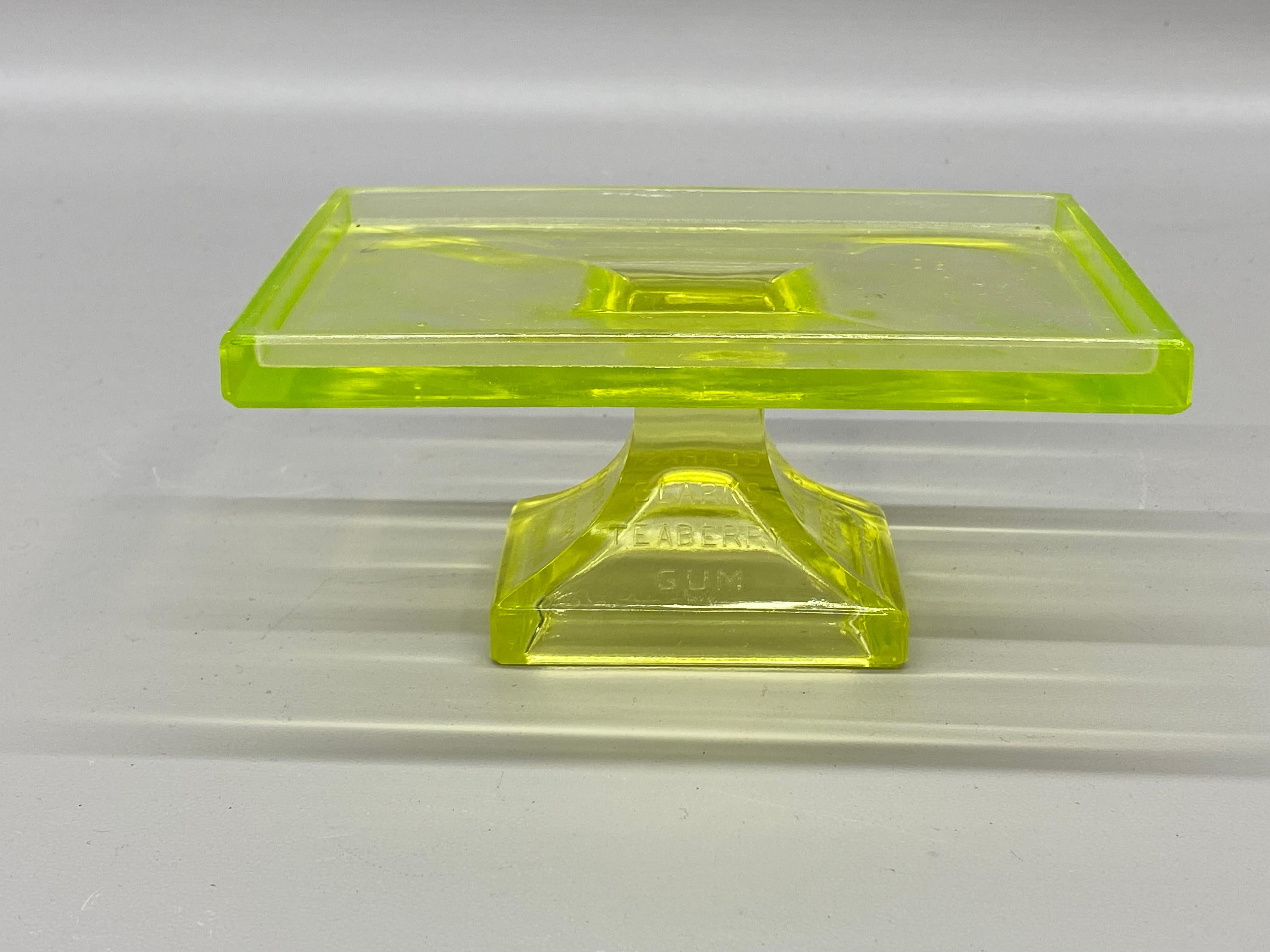 Fluoresces beautifully under a black light. Uranium glass Clark's Teaberry chewing gum store display stand. Circa 1920-30. A fantastic piece of advertising. 

Good overall condition with no visible chips, dings or cracks. Roughness to base edge from