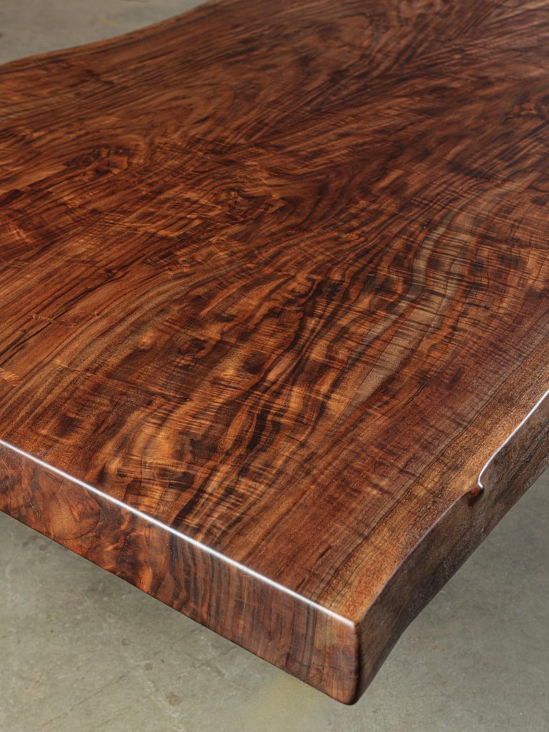 Live edge dining table featuring two incredibly figured, book-matched California Claro Walnut slabs.  Our steel cantilever base adds a brutalist aesthetic - a functional and extremely stable design. Slabs are exquisitely finished - any naturally